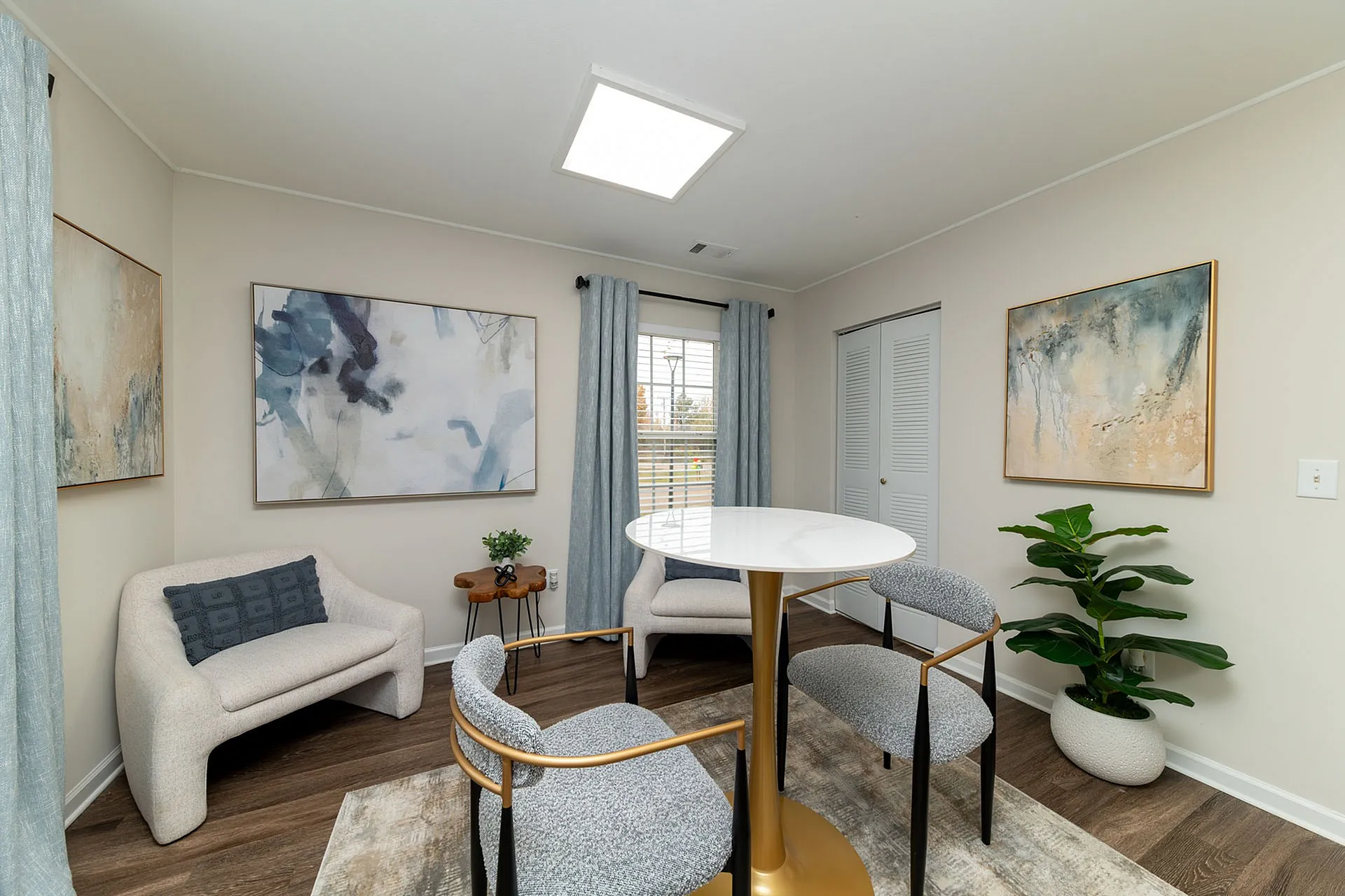 Chic and cozy living room with modern decor, featuring stylish chairs, abstract art, and a vibrant indoor plant.
