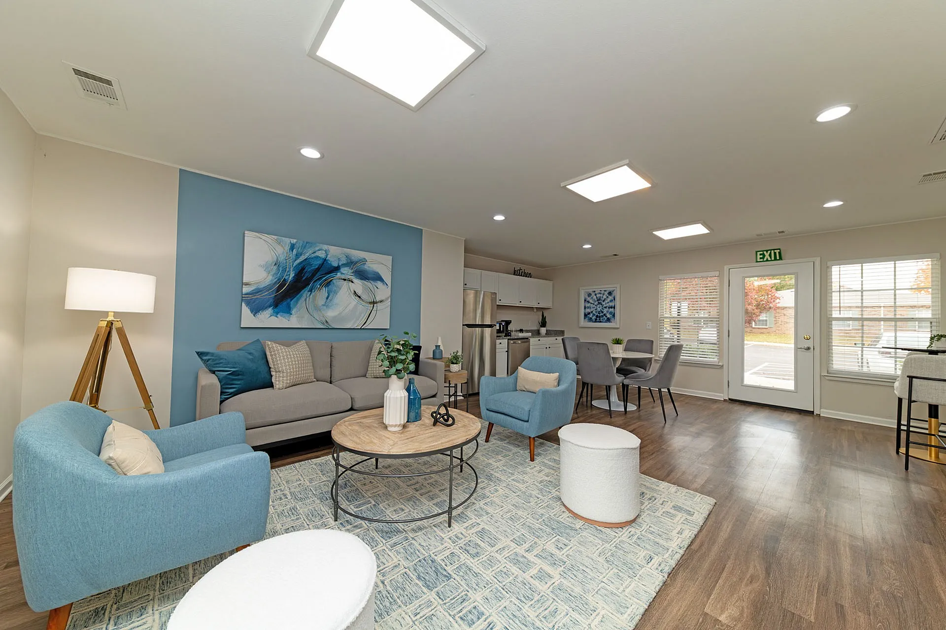 Chic open-concept living and dining area with modern seating, elegant wood flooring, and abundant natural light, ideal for stylish living.