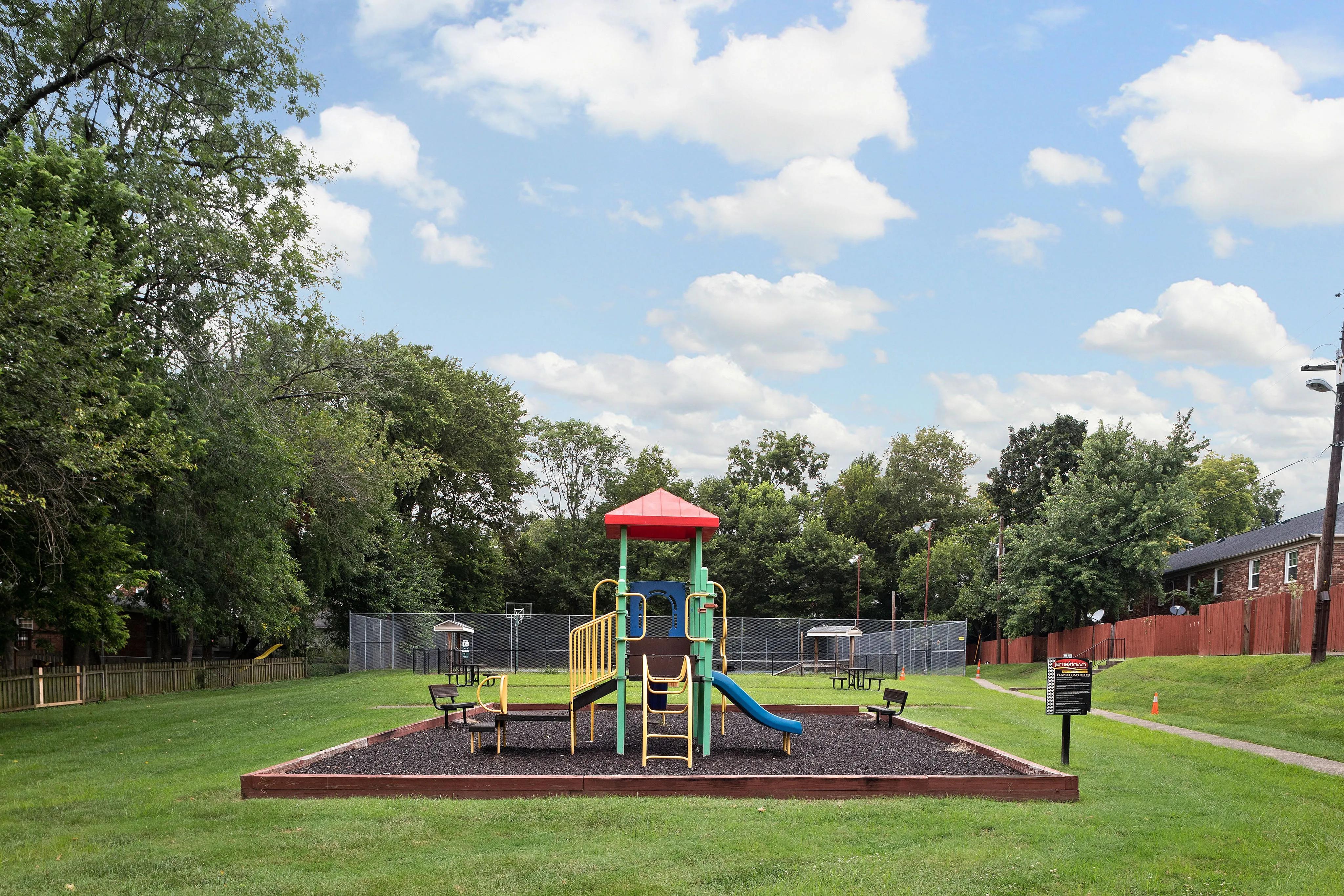 Charming playground with vibrant slides nestled in a lush green park setting, perfect for family fun and outdoor activities.