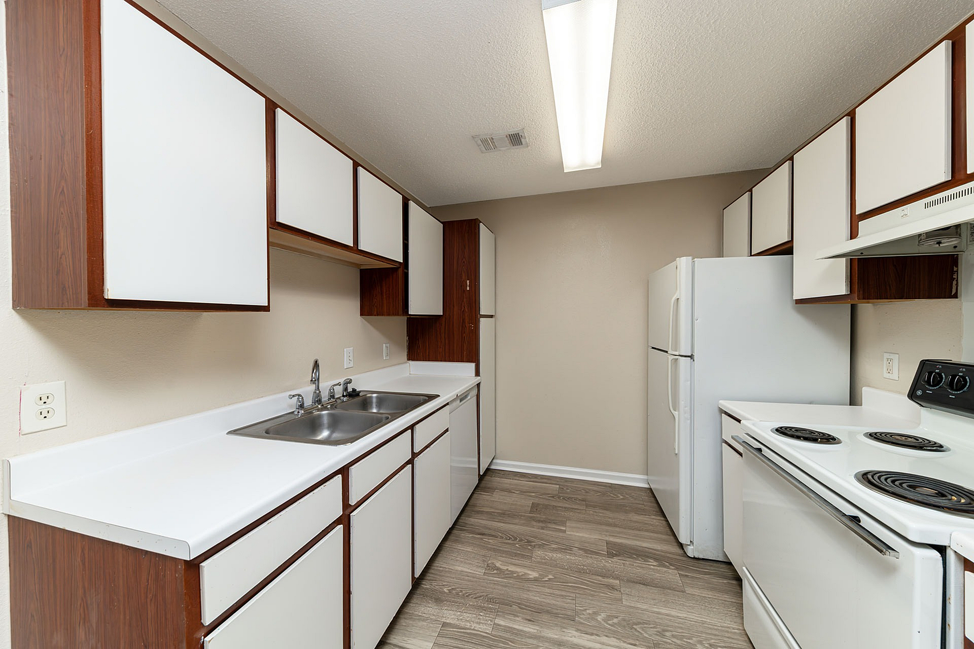Modern kitchen with sleek wooden cabinets, dual sinks, and energy-efficient appliances offers a stylish cooking space.