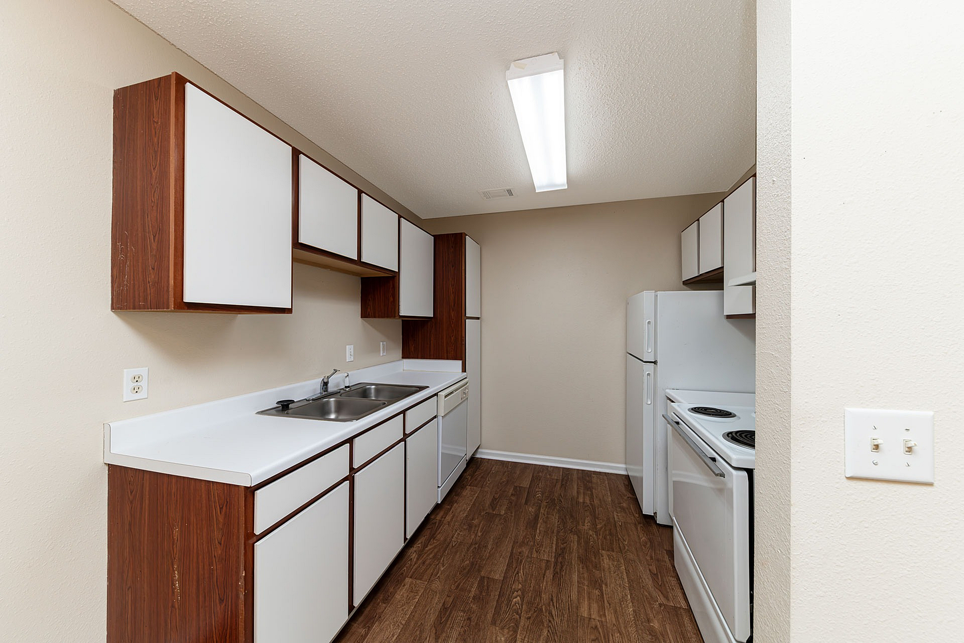 Charming kitchen with modern white cabinetry, sleek countertops, and elegant wood flooring, perfect for culinary creations.