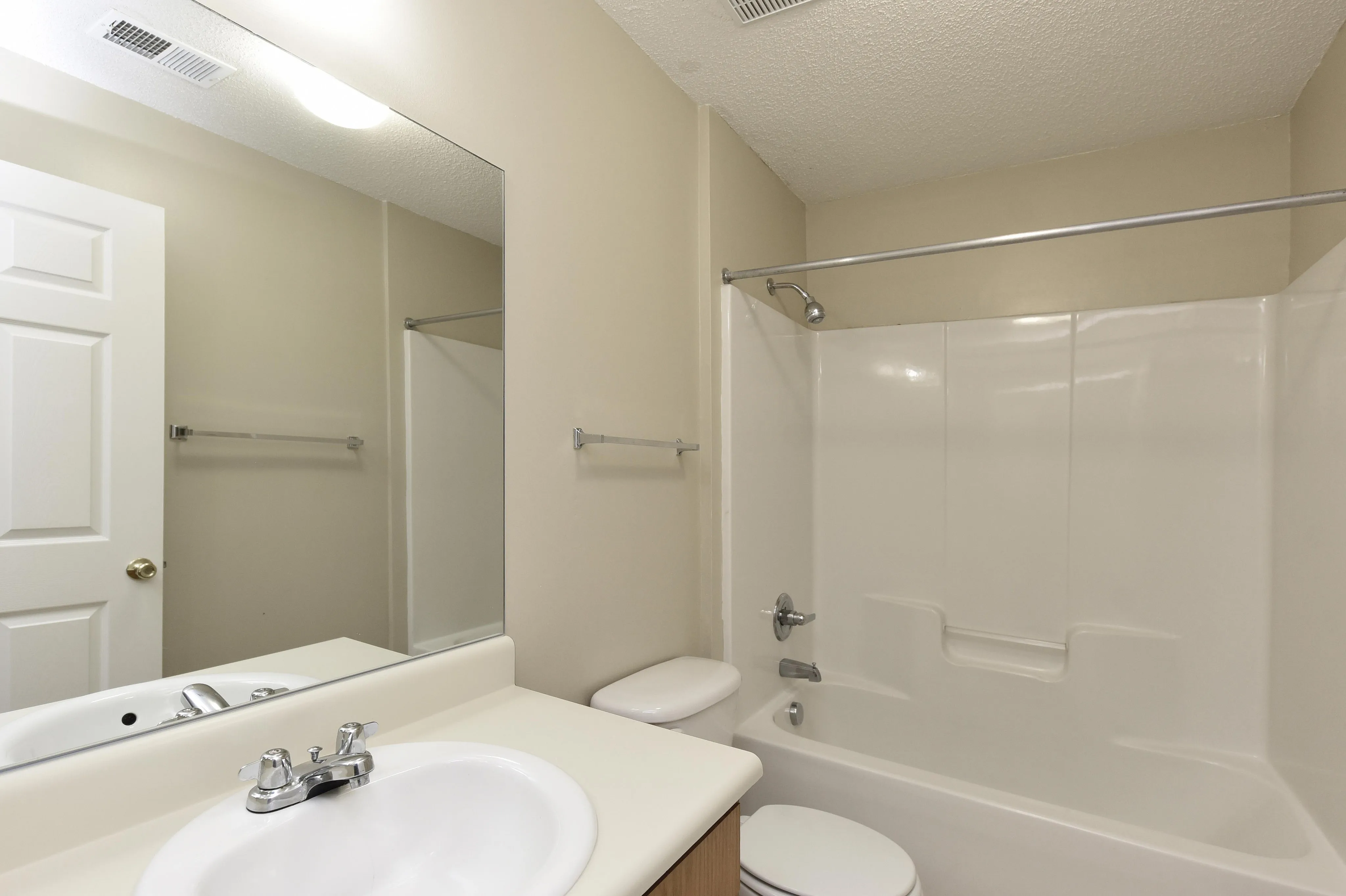 Modern bathroom with sleek, white fixtures and a spacious tub, perfect for relaxation and comfort.