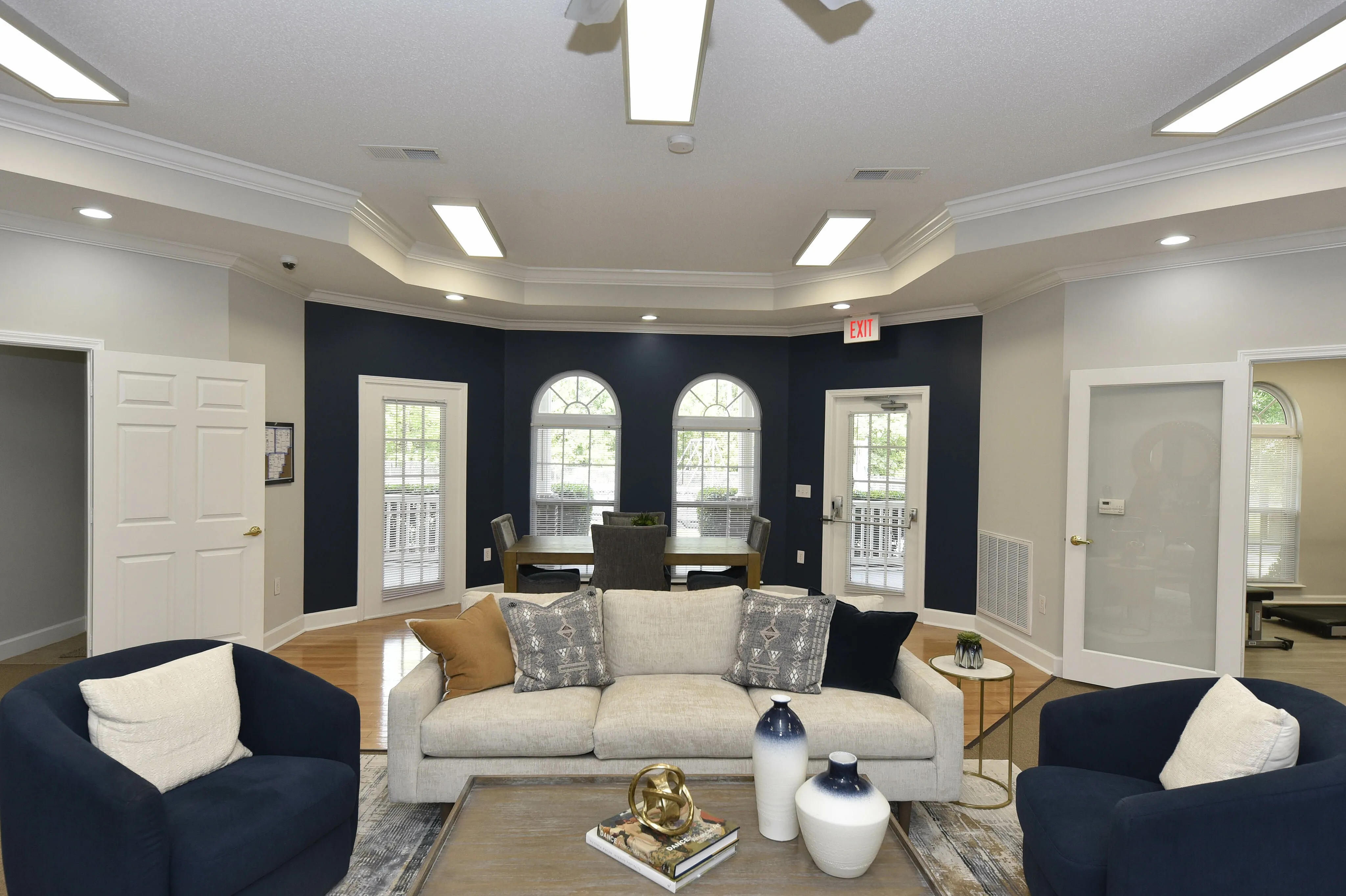 Elegant living room with plush seating, tasteful decor, and large arched windows offering natural light.