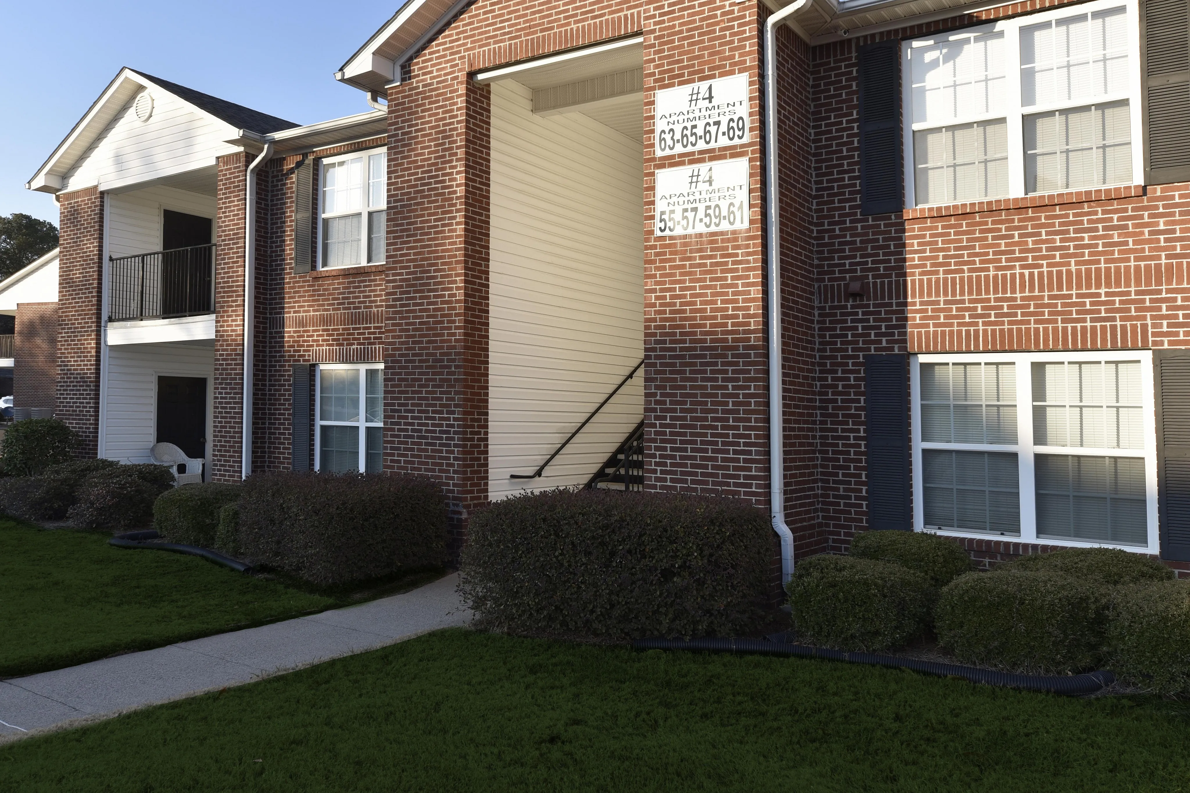 Charming brick apartment building with attractive manicured landscaping and inviting entryway.