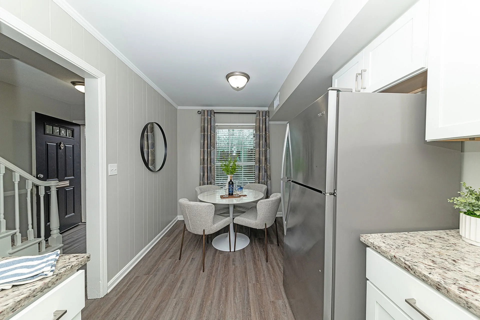 Charming kitchen nook with modern appliances, elegant dining area, and cozy window view.