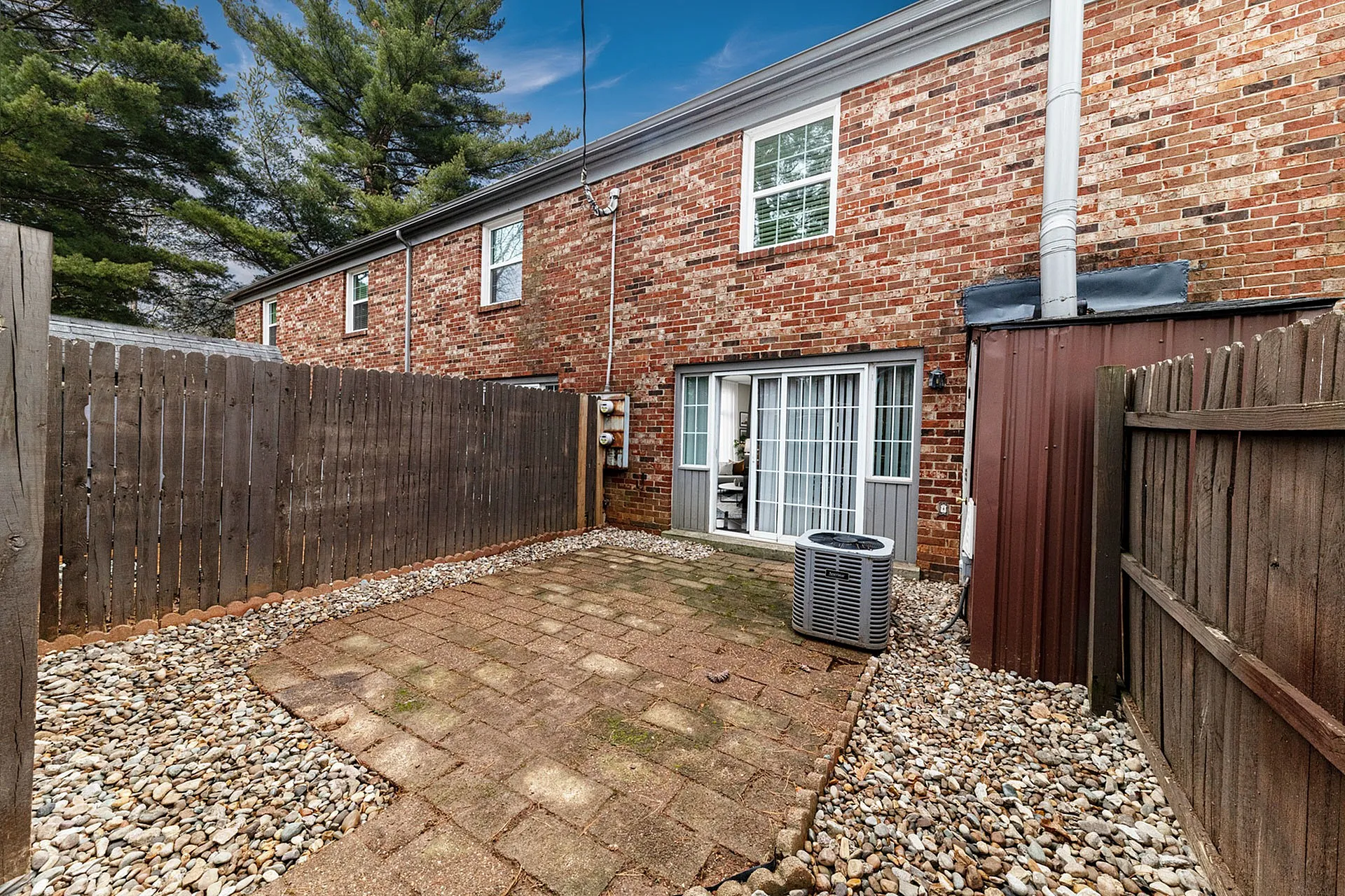 Charming brick townhouse with a private fenced patio, perfect for outdoor relaxation and entertaining.