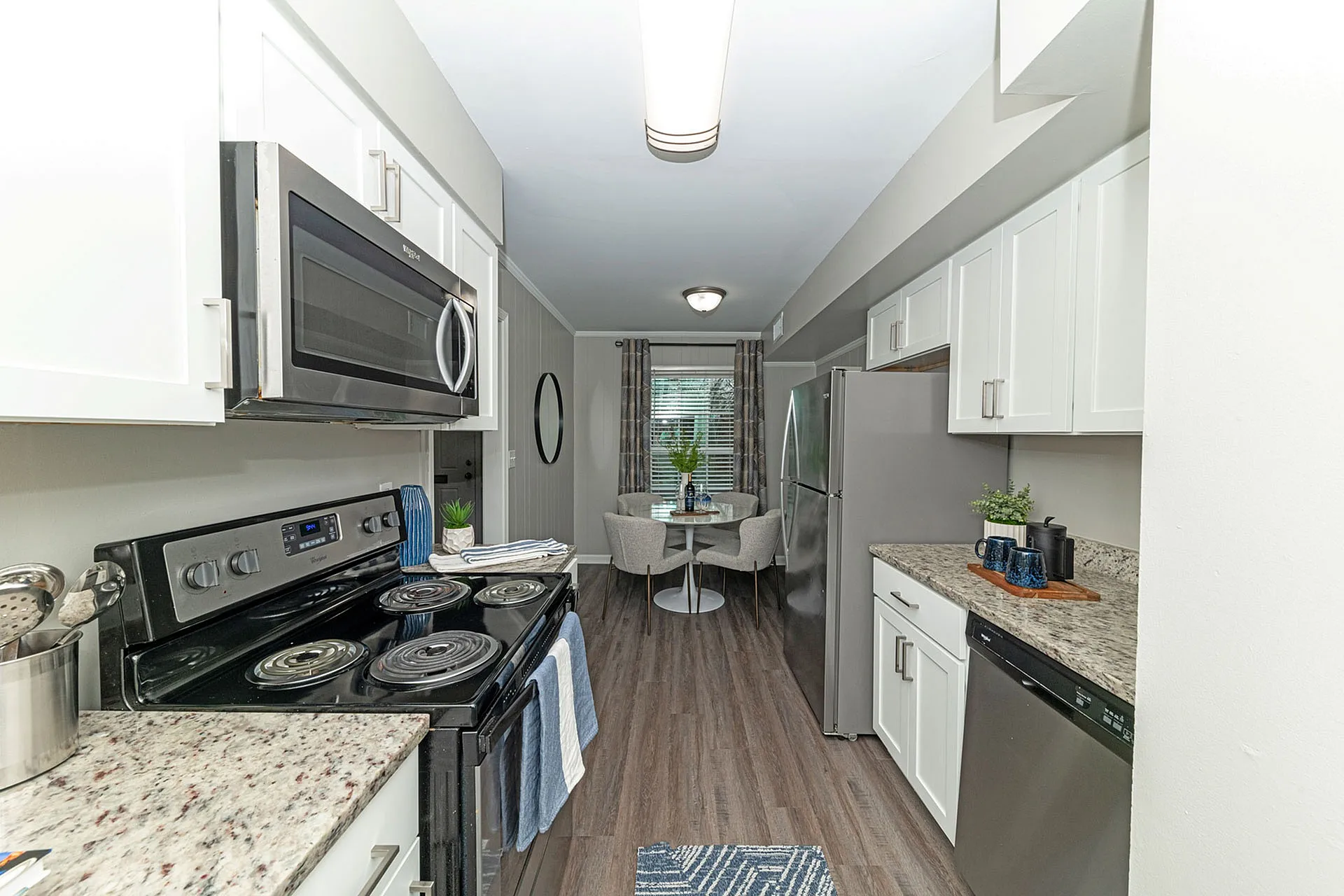 Modern kitchen with sleek stainless steel appliances, stylish granite countertops, and a charming dining nook with elegant seating, ideal for cozy gatherings.