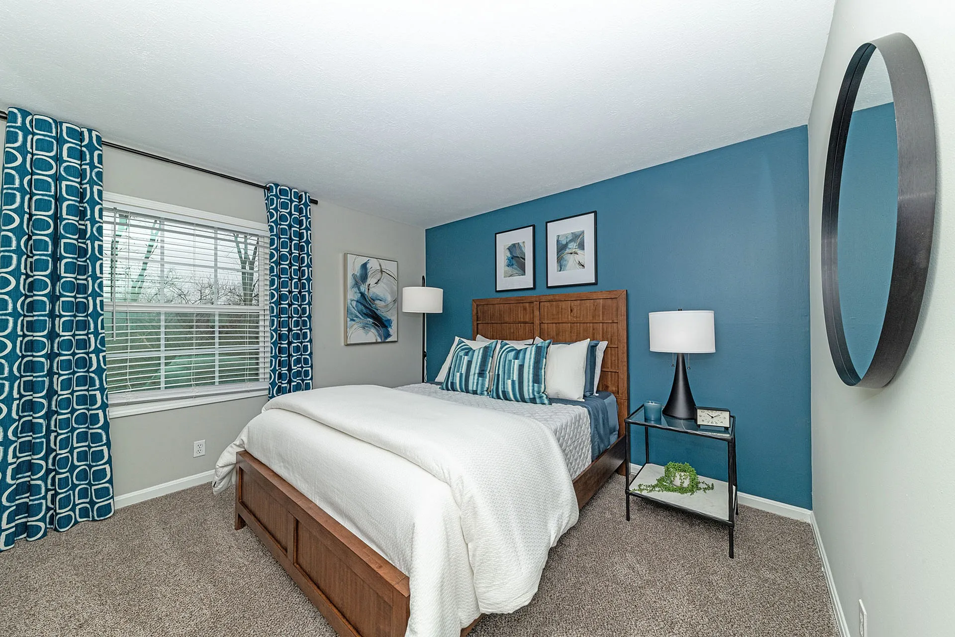 Inviting bedroom with elegant blue accents, featuring a cozy bed, stylish decor, and a serene ambiance.