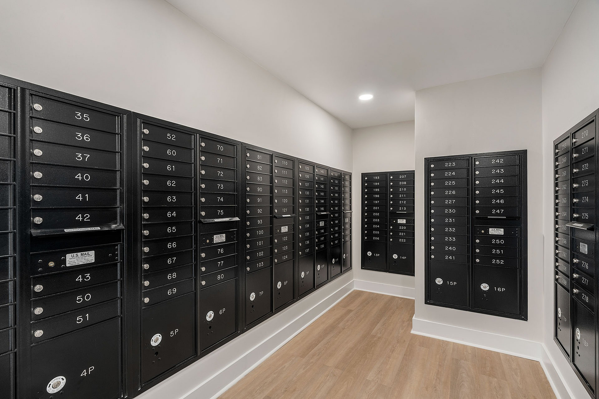 Modern mailroom with sleek black mailboxes in a well-lit, spacious area, offering convenience and security for residents.