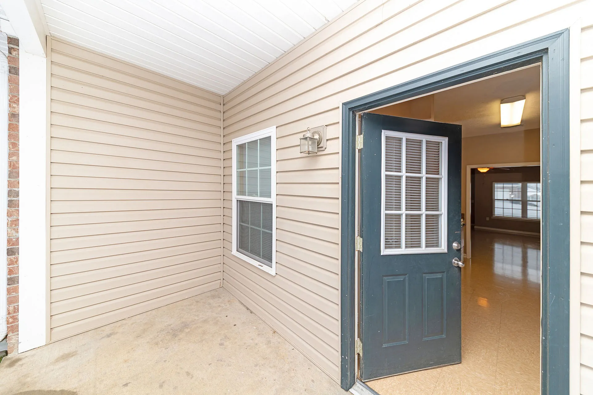 Inviting entryway with a modern design, showcasing a welcoming porch and elegant glass-panel door leading into a bright, spacious interior.