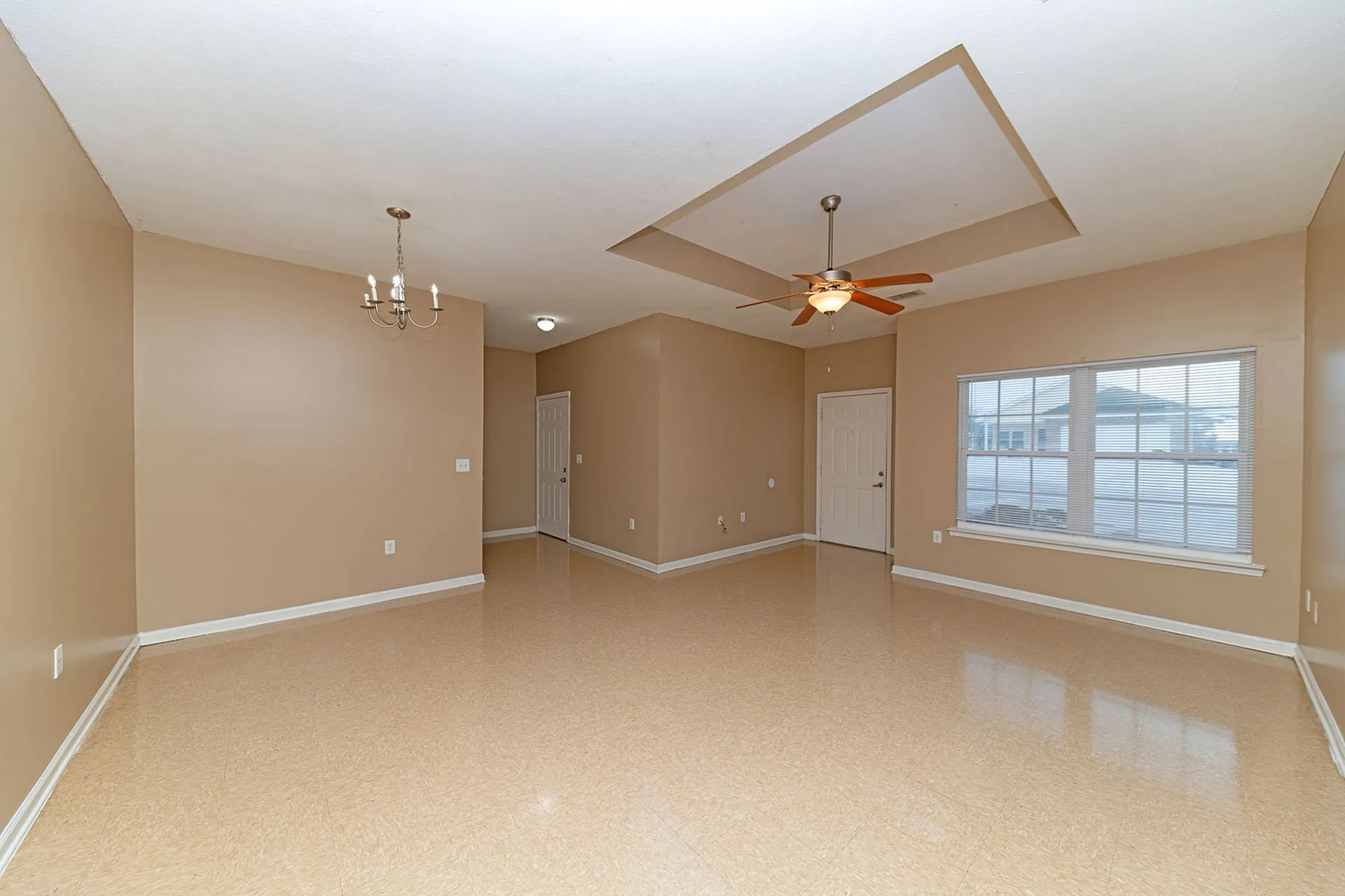 Spacious and inviting open-plan living area with glossy floors, elegant ceiling fan, and ambient lighting, ready for your personal touch.