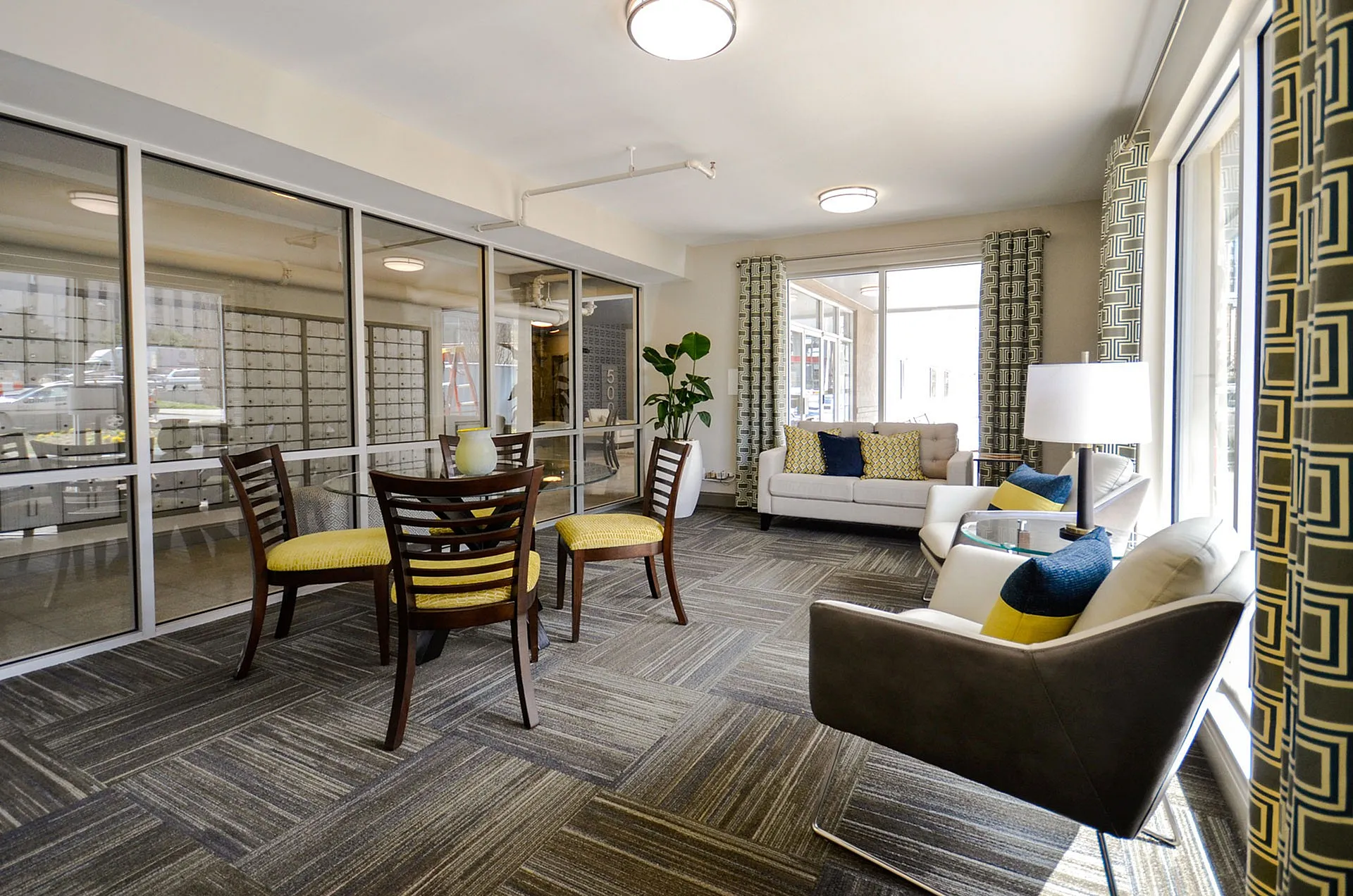Inviting urban lounge area with contemporary furniture, bright accents, and floor-to-ceiling windows offering ample natural light.