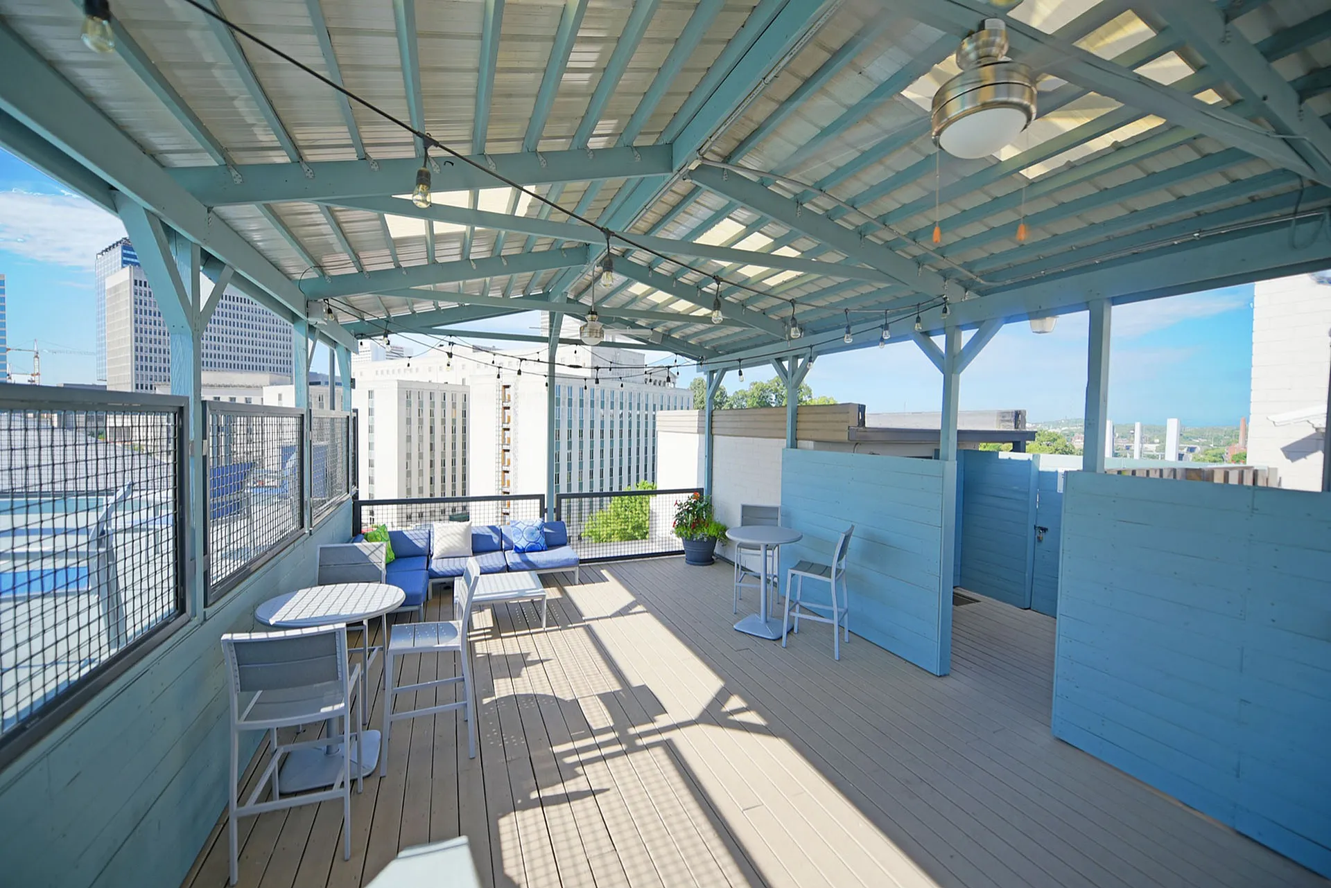 Charming rooftop terrace with modern seating, vibrant city views, and stylish blue accents, perfect for entertaining.
