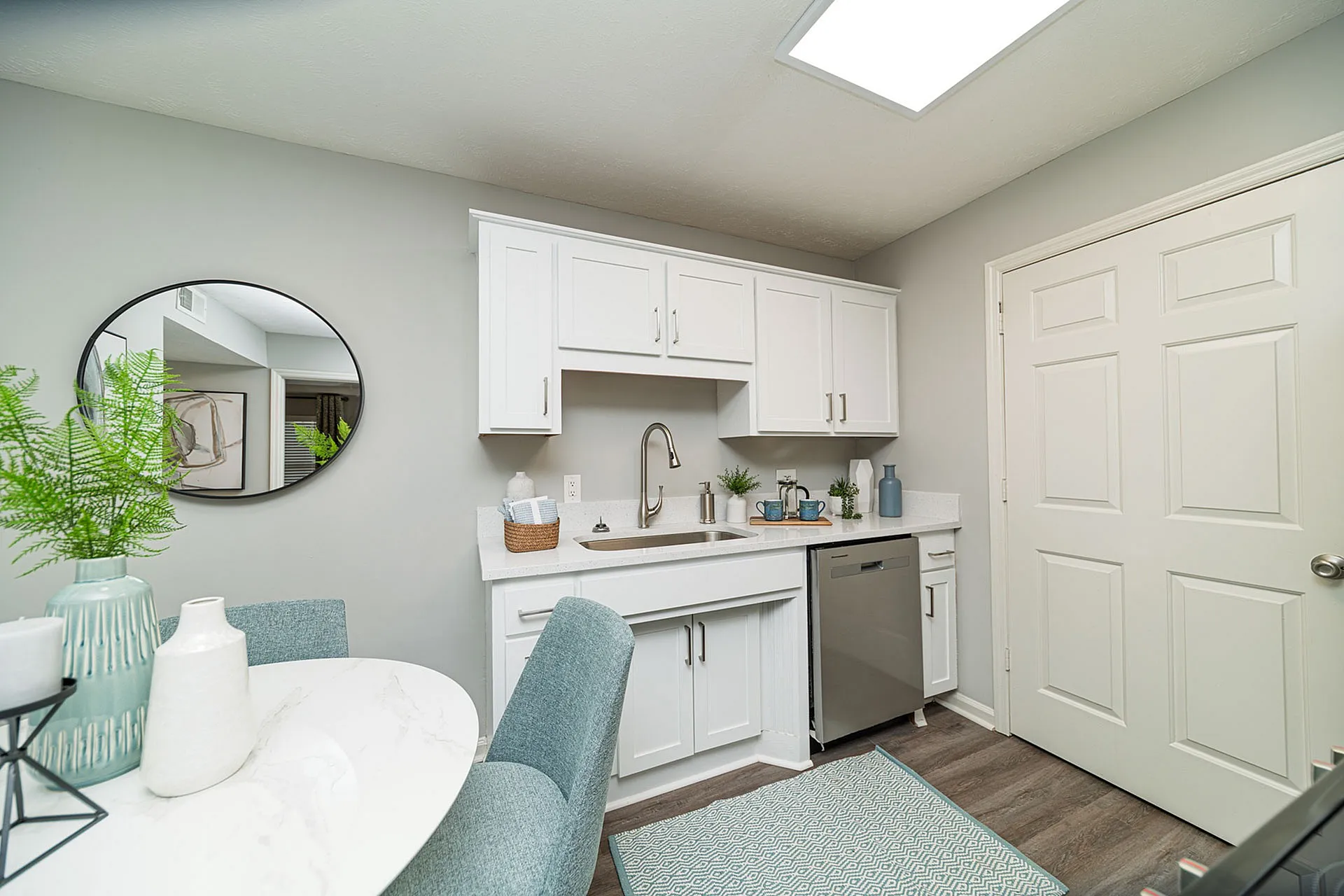 Charming kitchen with sleek white cabinetry, elegant decor, and modern stainless steel appliances, perfect for a cozy dining experience.
