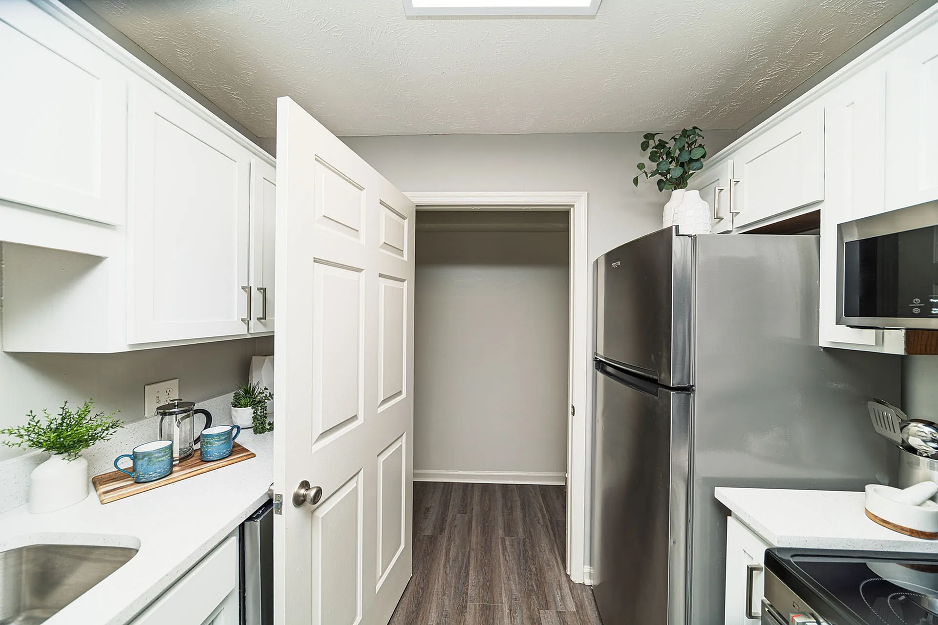 Bright and modern kitchen with sleek stainless steel appliances, white cabinetry, and elegant decor accents.