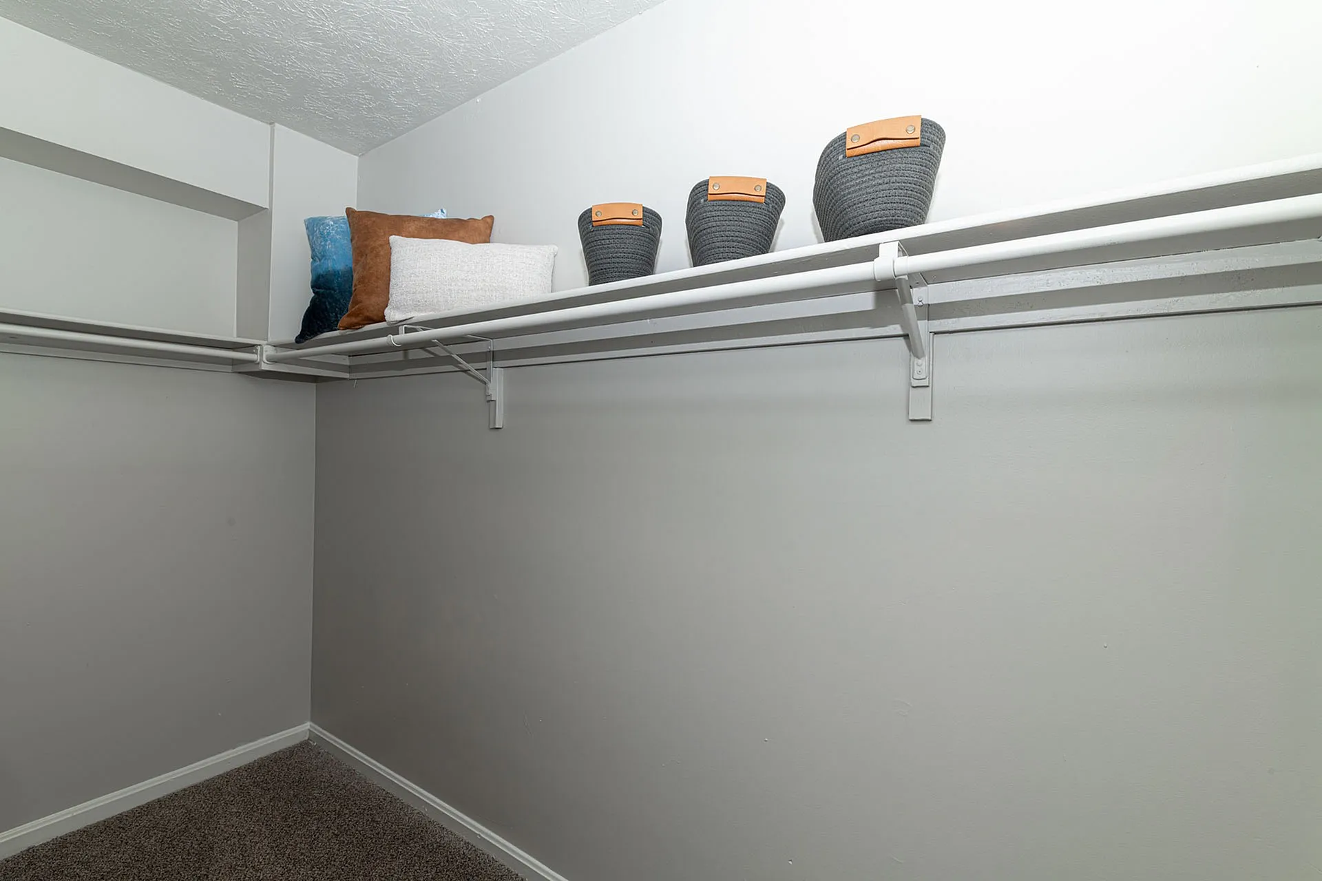 Spacious walk-in closet with ample shelving and stylish storage baskets, perfect for organizing your wardrobe.