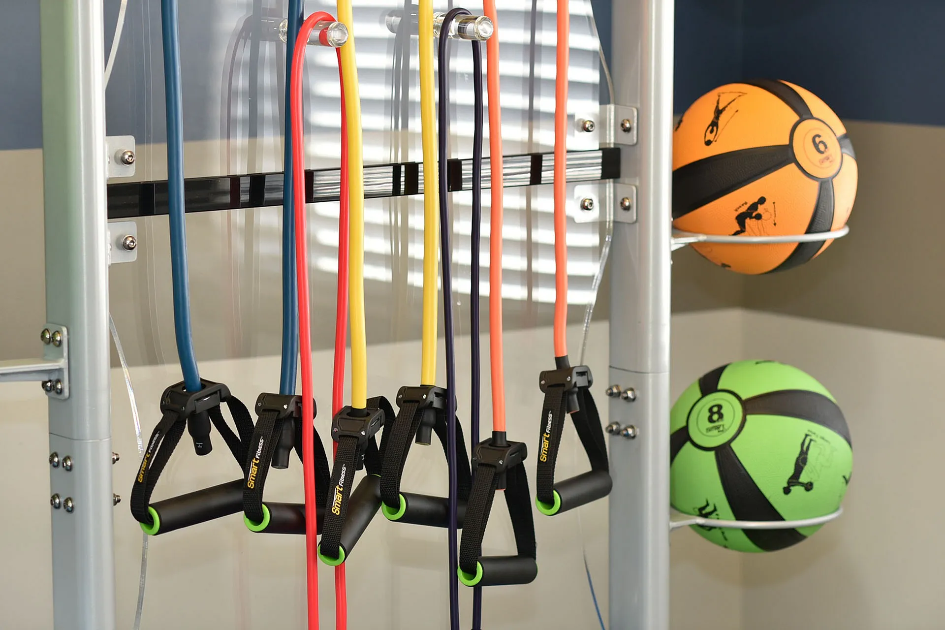 Modern gym equipment setup with vibrant resistance bands and energetic medicine balls for a dynamic workout experience.