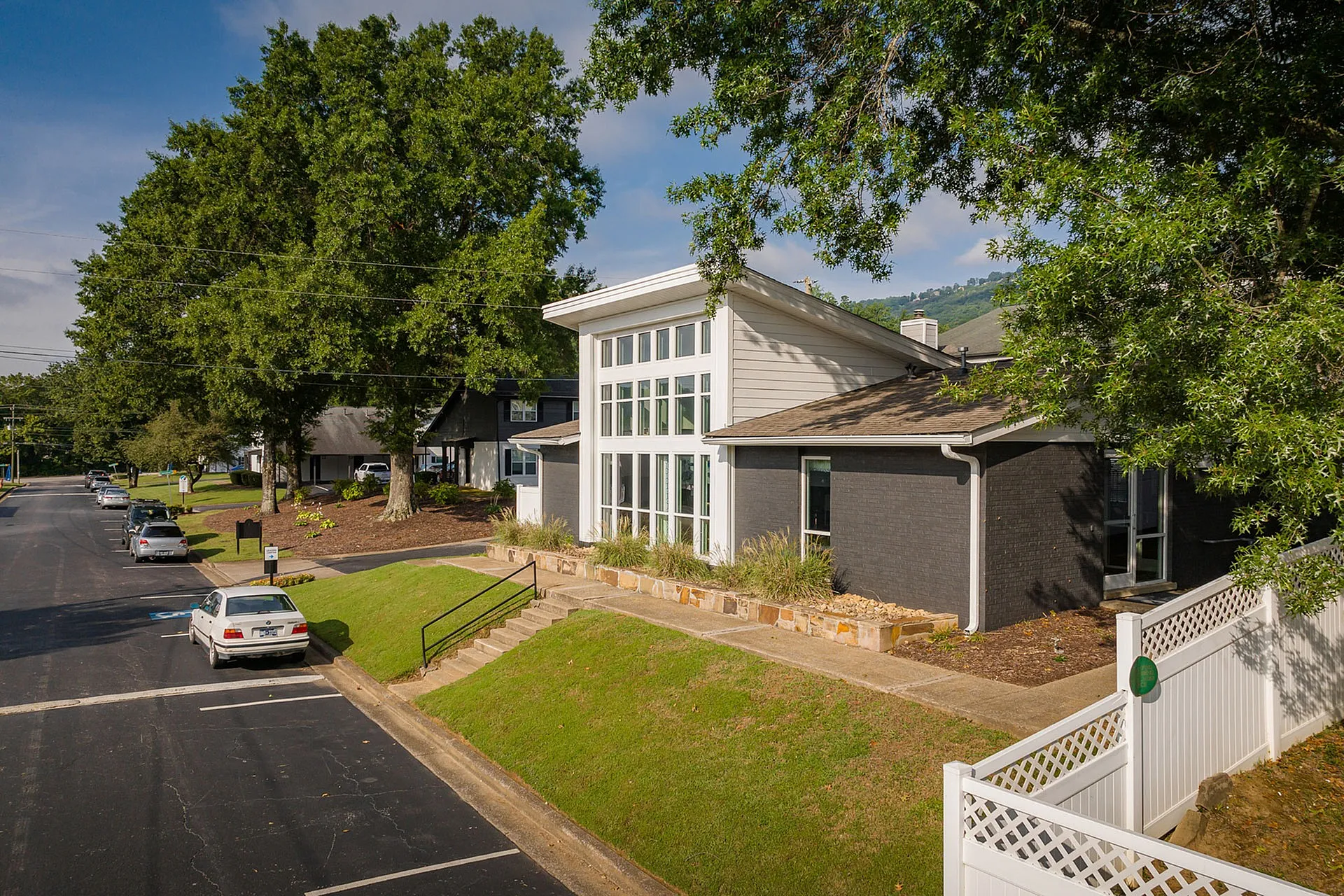Charming residential property with lush green surroundings, featuring a modern exterior with expansive windows and elegant landscaping.