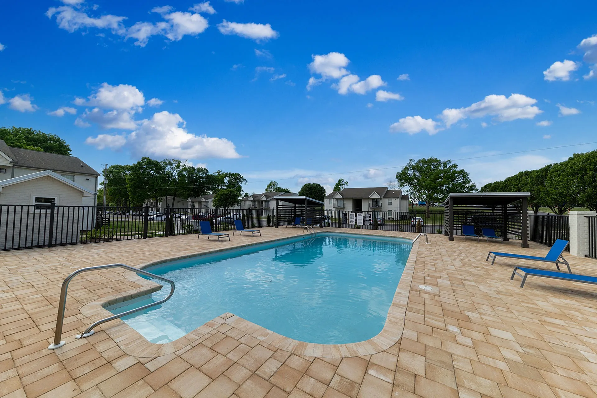 Inviting outdoor pool with stylish lounge chairs and serene surroundings, perfect for relaxation.