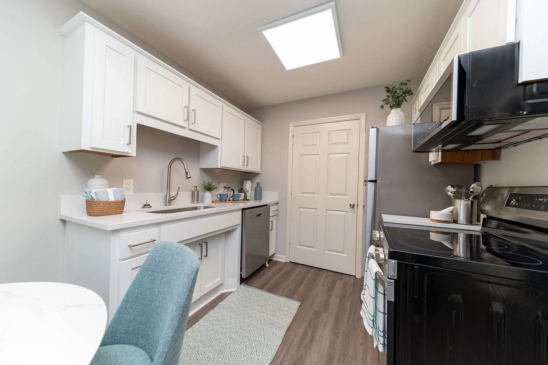 Bright, modern kitchen with sleek white cabinetry, stainless steel appliances, and hardwood floors, perfect for culinary creativity.