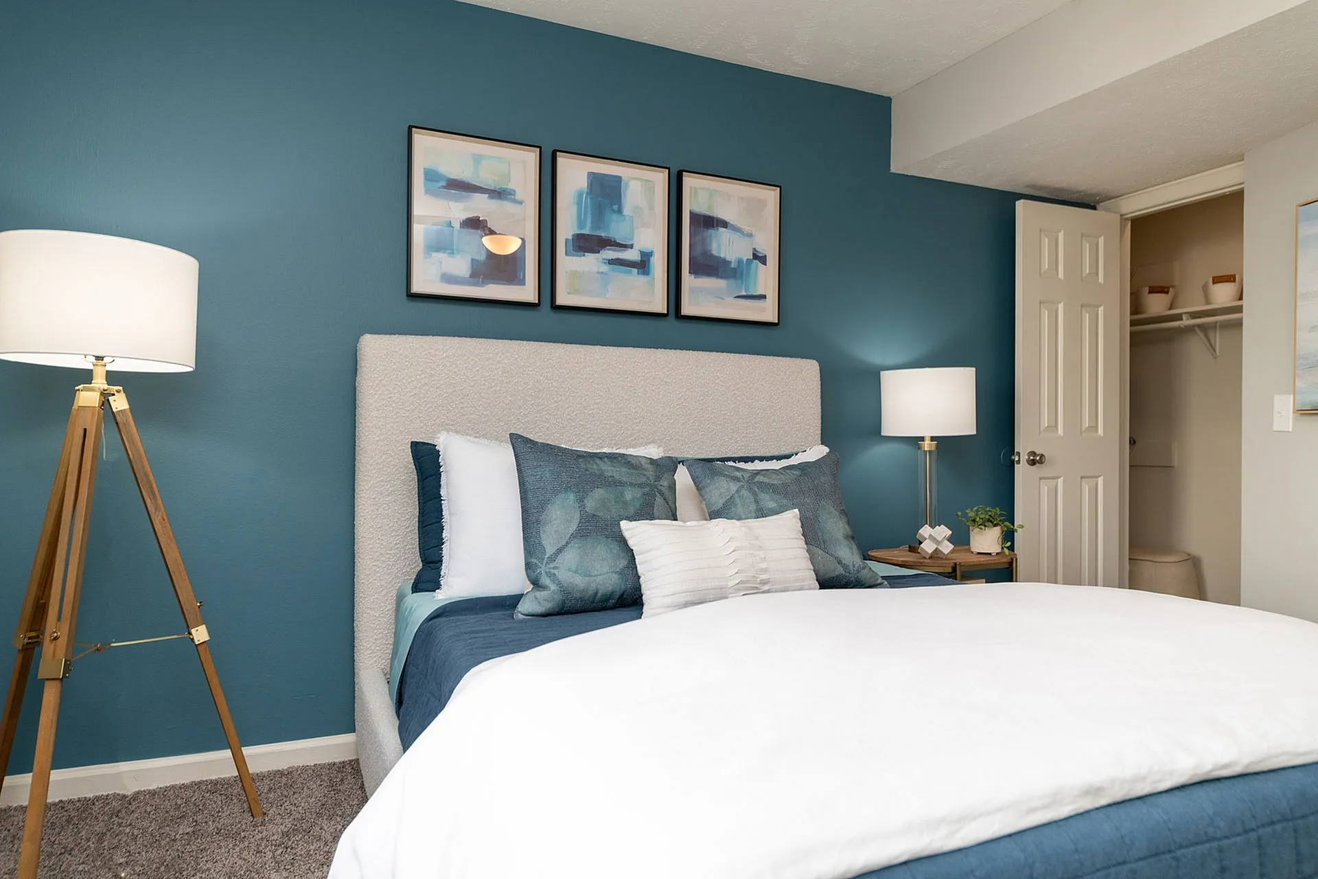 Inviting bedroom with teal accent wall, stylish decor, and cozy bedding, perfect for relaxation and comfort.