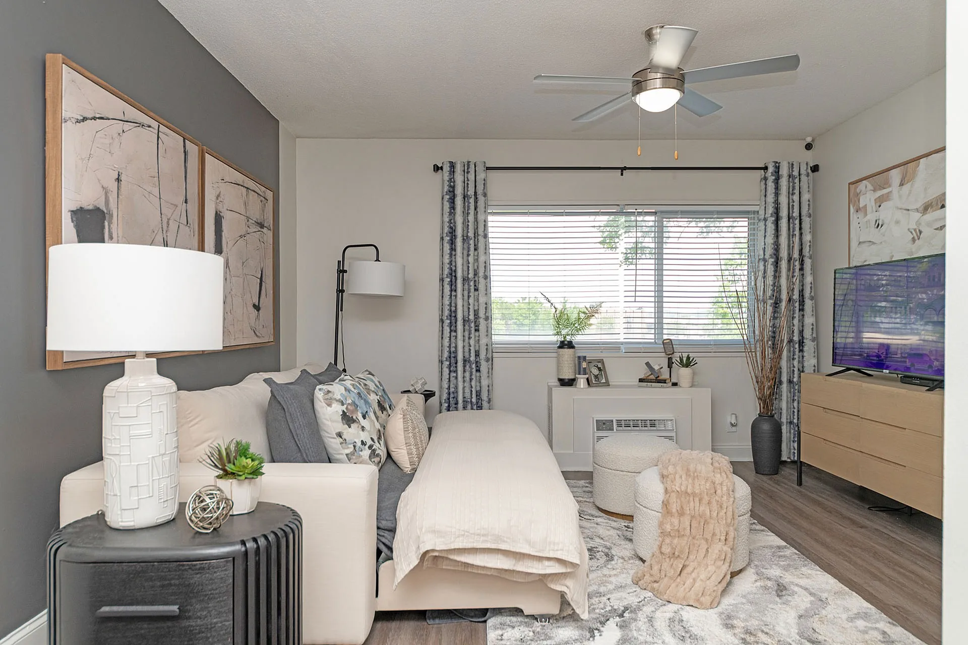 Elegant living space with plush seating, chic decor, and a large window for natural lighting, perfect for modern comfort.