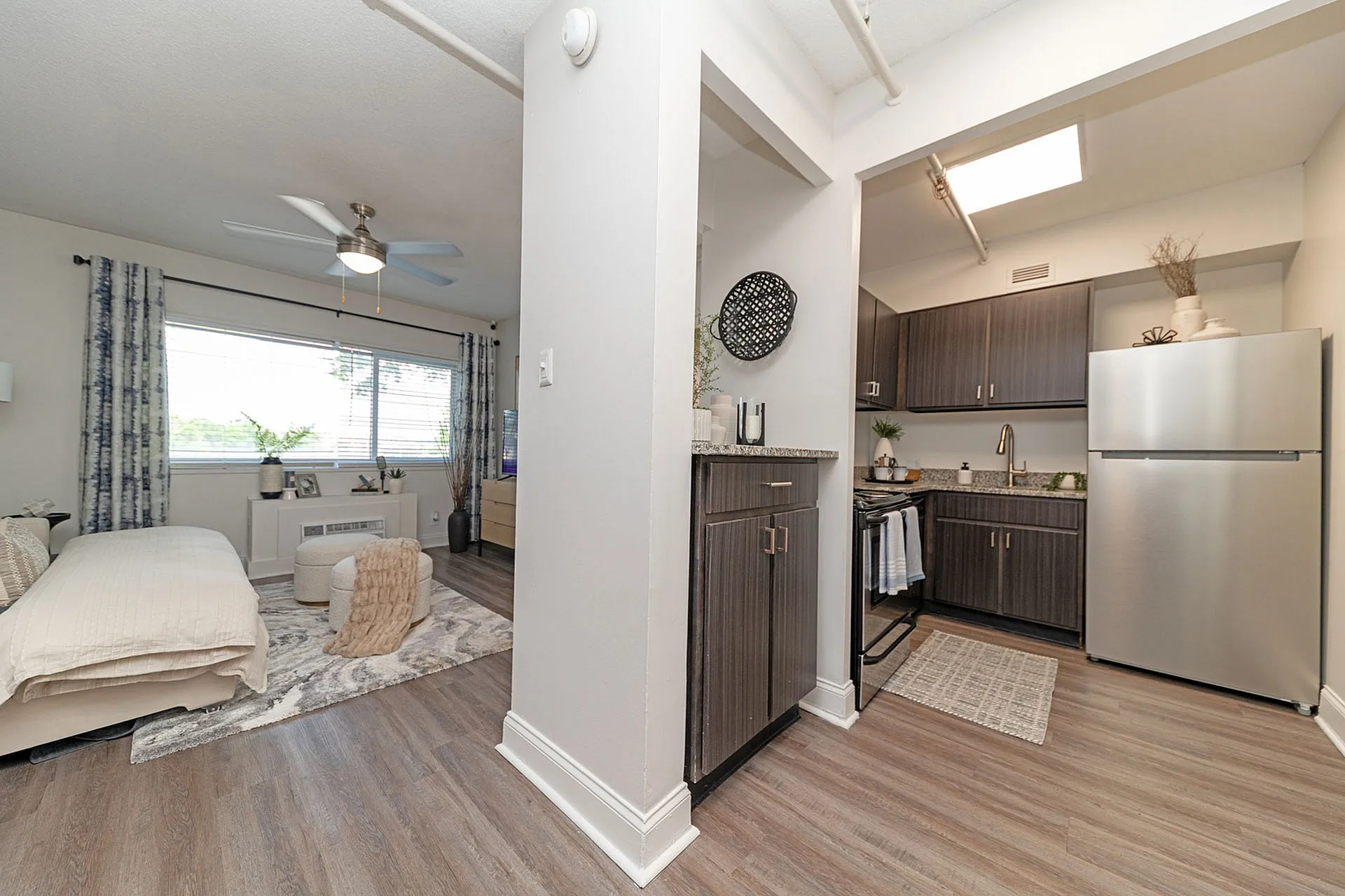 Inviting open-plan apartment with a modern kitchen, cozy living area, and sleek wood flooring, perfect for comfortable urban living.