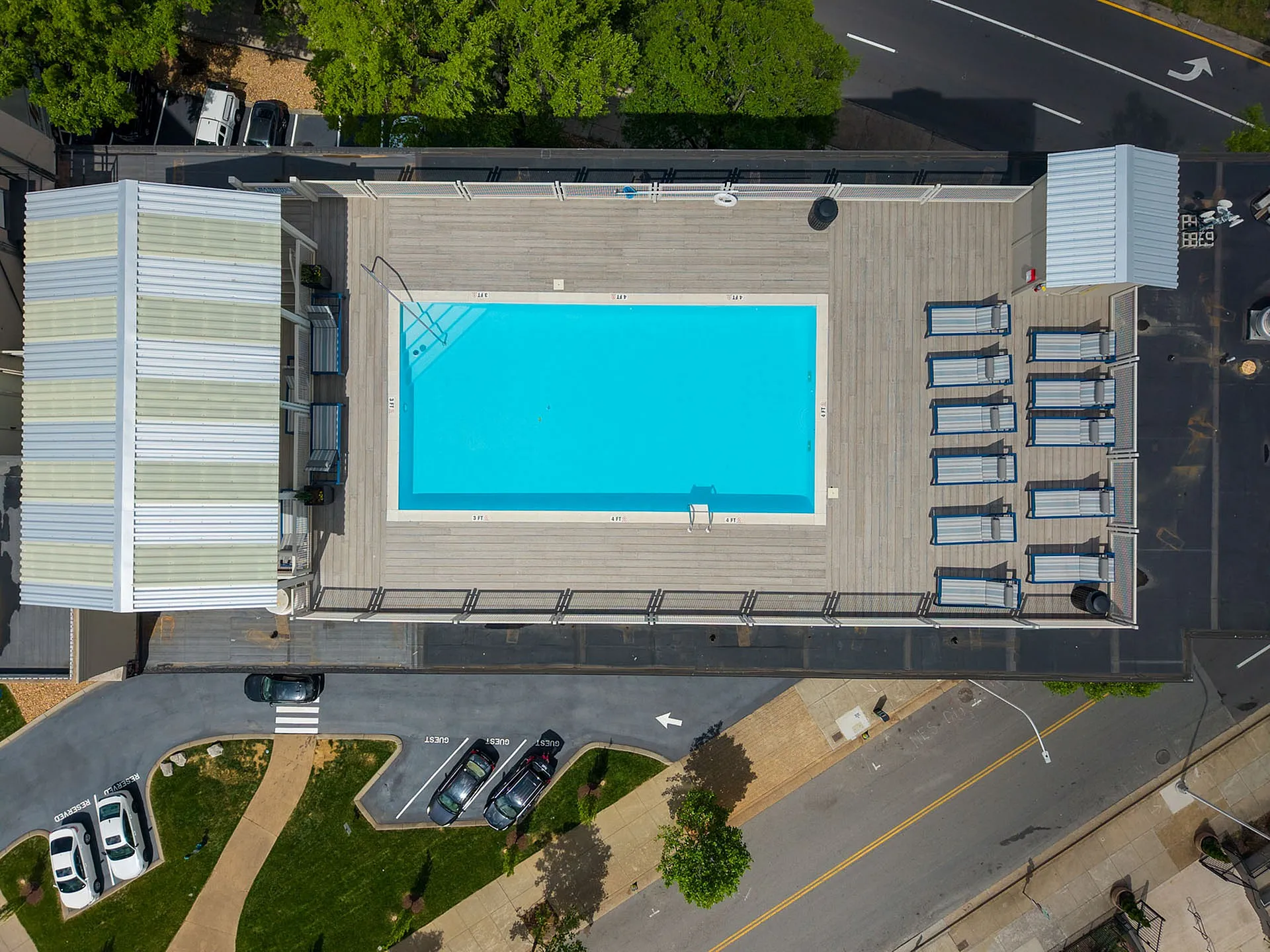 Chic rooftop swimming pool with a spacious deck, surrounded by stylish lounge chairs, offering a luxurious urban escape.