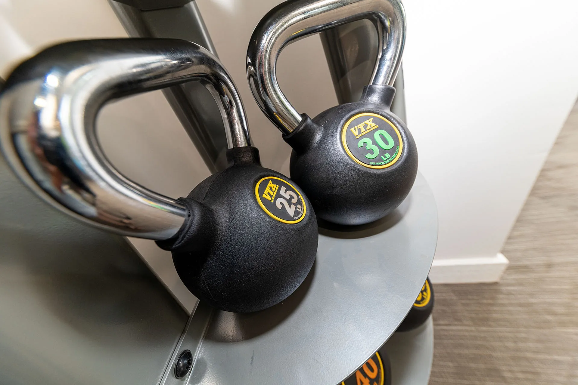 High-quality fitness area featuring sleek kettlebells on a modern rack, perfect for a well-equipped workout space.