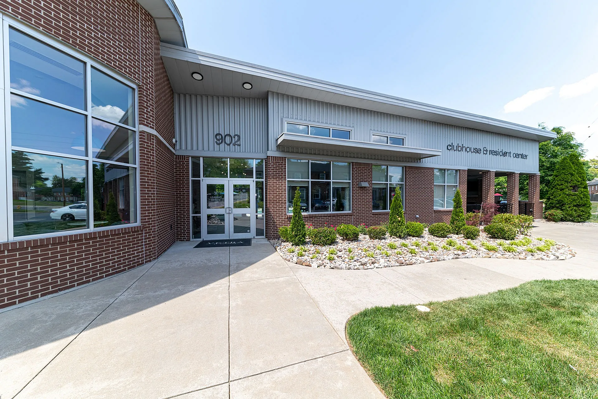 Modern clubhouse and resident center with brick facade, large windows, and landscaped entrance.