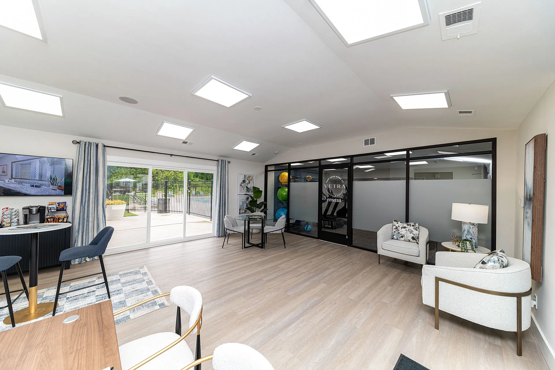 Bright and modern community lounge featuring sleek furniture, large windows, and a cozy sitting area.