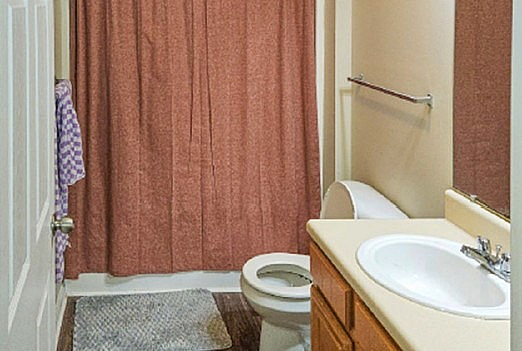 Cozy bathroom featuring a sleek sink, elegant countertop, and stylish shower curtain for a comfortable living space.