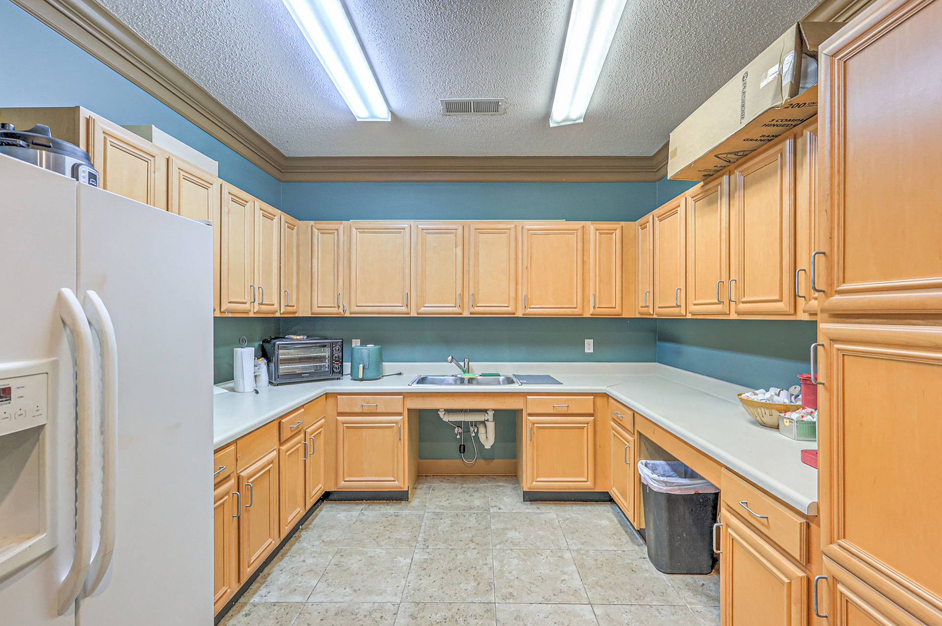 Charming U-shaped kitchen featuring ample wooden cabinetry, sleek countertops, and modern appliances for a cozy cooking experience.