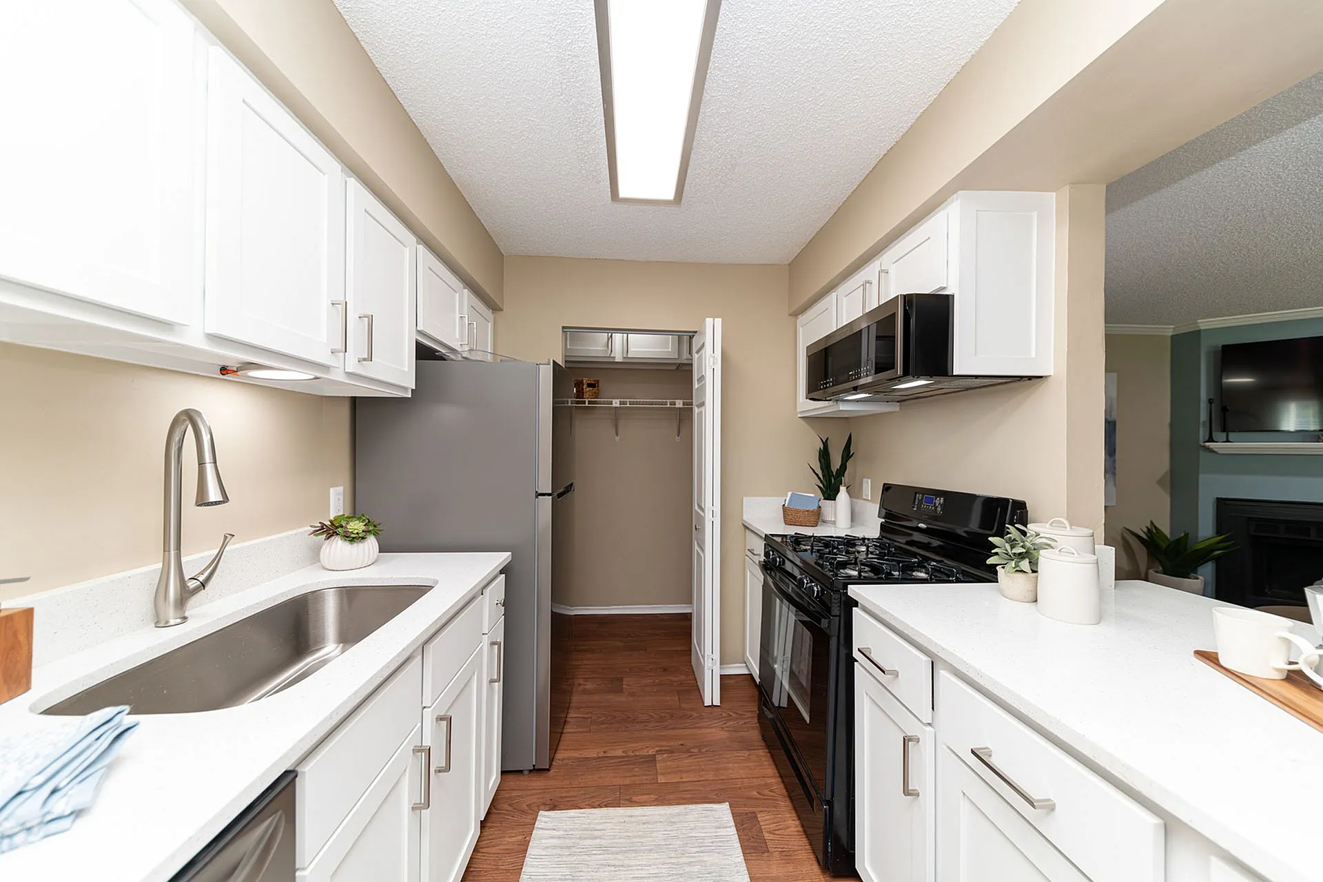 Modern kitchen with sleek white cabinetry, stainless steel appliances, and elegant countertops, offering a bright and inviting cooking space.
