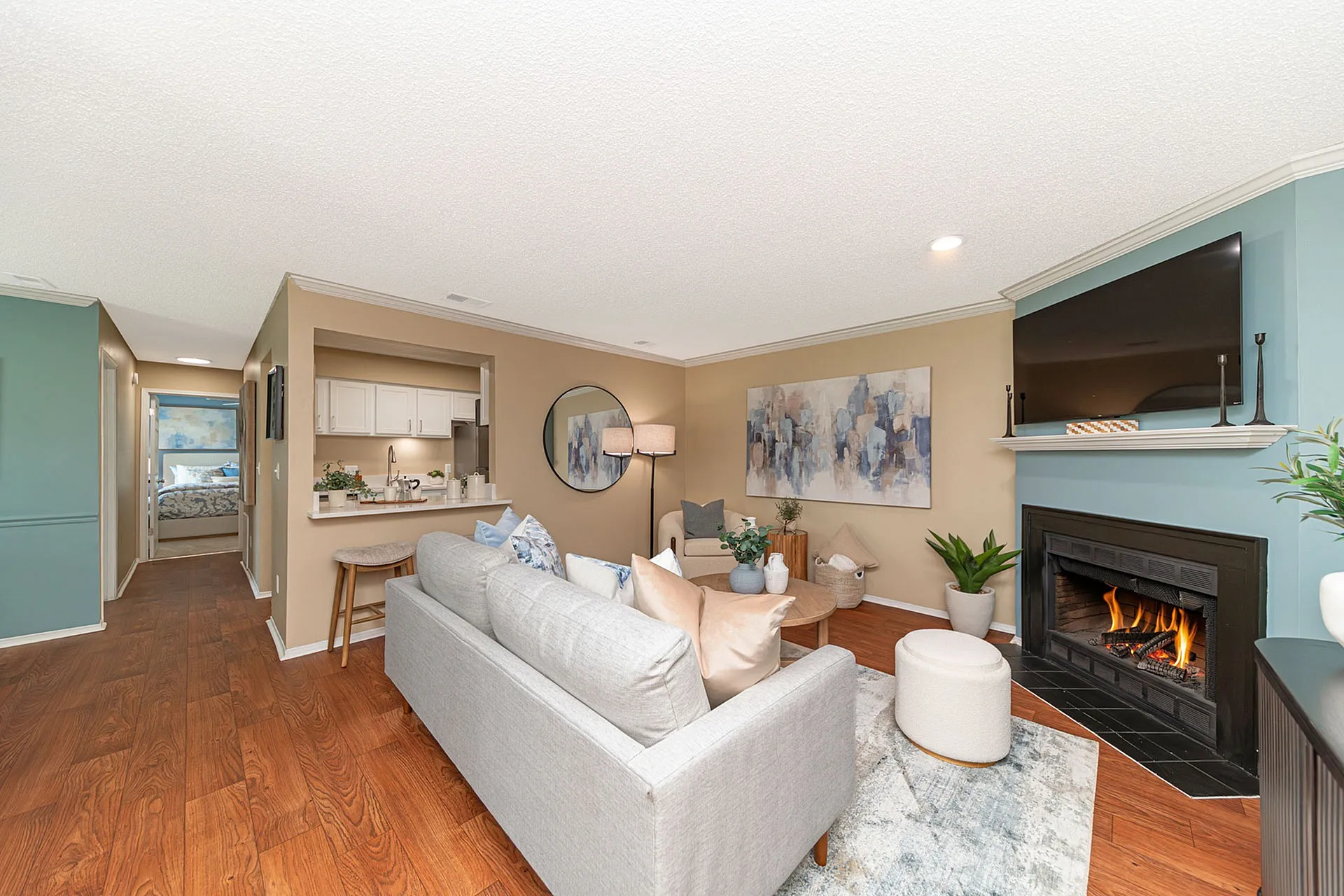 Inviting living area with cozy fireplace, elegant decor, and modern open-concept kitchen.