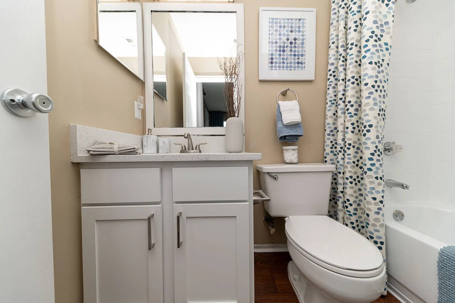 Chic bathroom with modern white vanity, sleek fixtures, and stylish patterned shower curtain, optimized for relaxation.