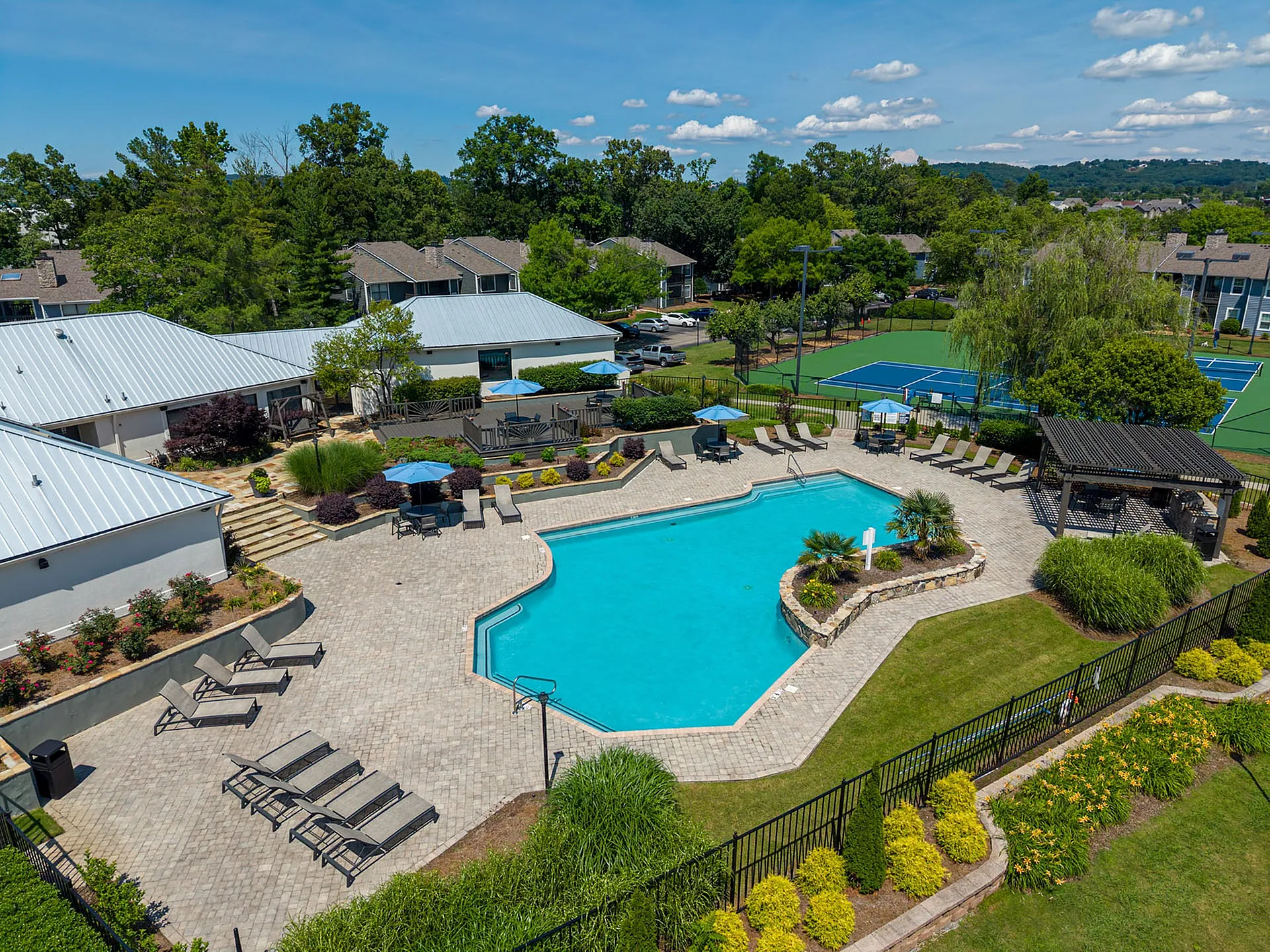 Charming apartment complex features a pristine swimming pool, lush landscaped gardens, and modern tennis courts, ideal for relaxation and recreation.