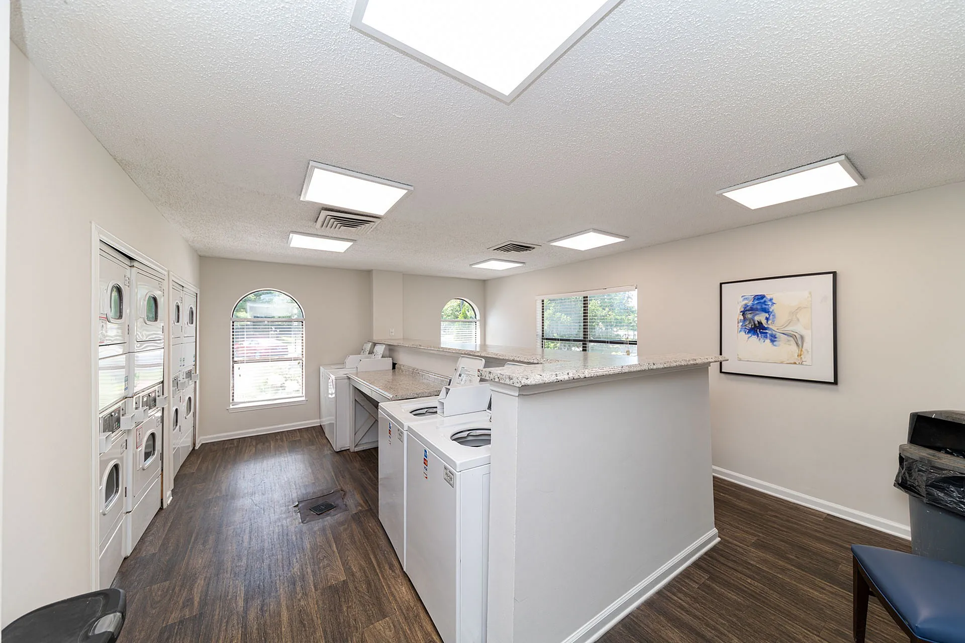 Bright and modern laundry room featuring sleek washing machines, elegant countertops, and stylish decor.