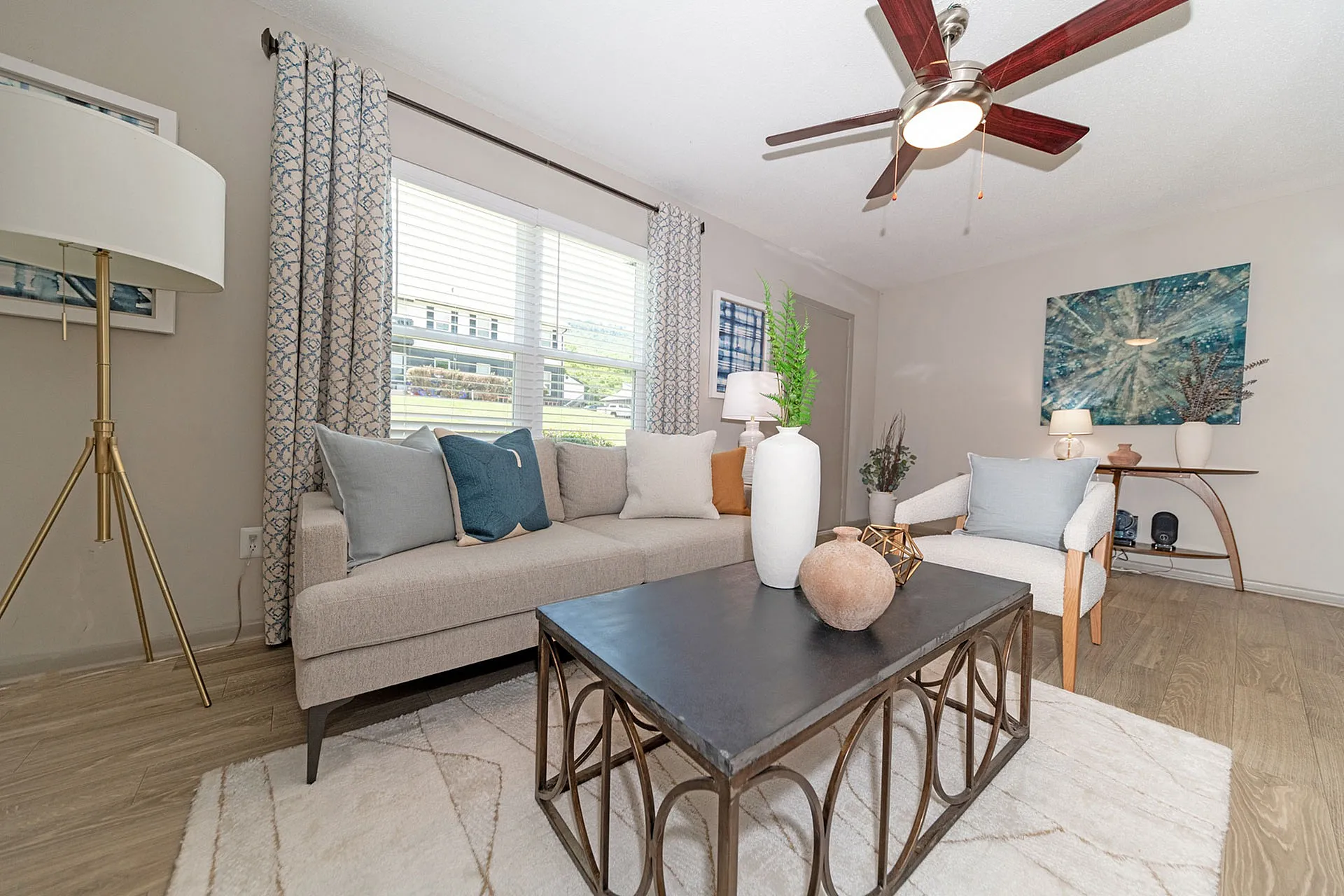 Contemporary living room with stylish decor, featuring a cozy beige sofa, elegant lighting, and artistic wall art, perfect for relaxation.