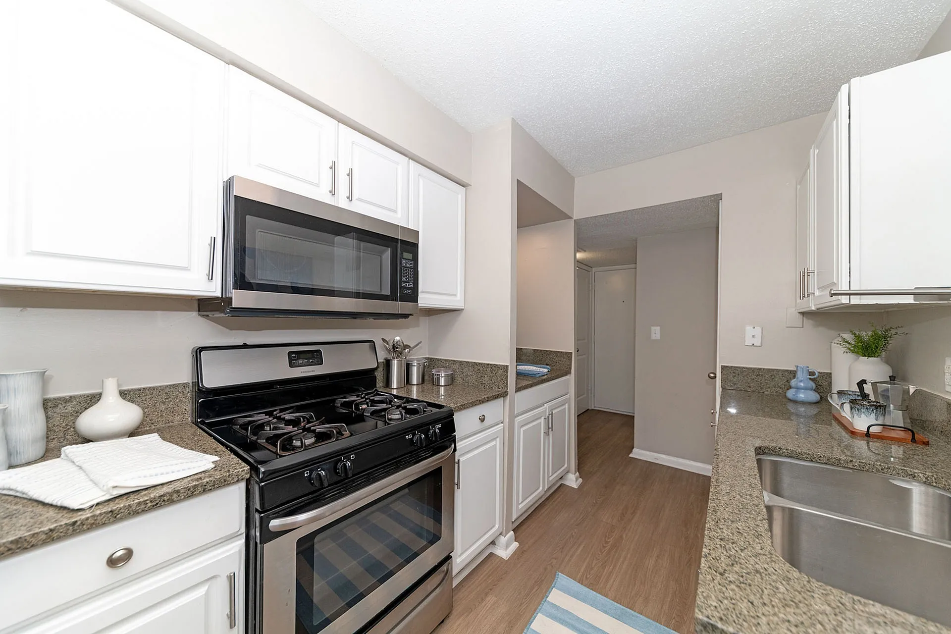 Bright and modern kitchen with sleek granite countertops, stainless steel appliances, and elegant white cabinetry.