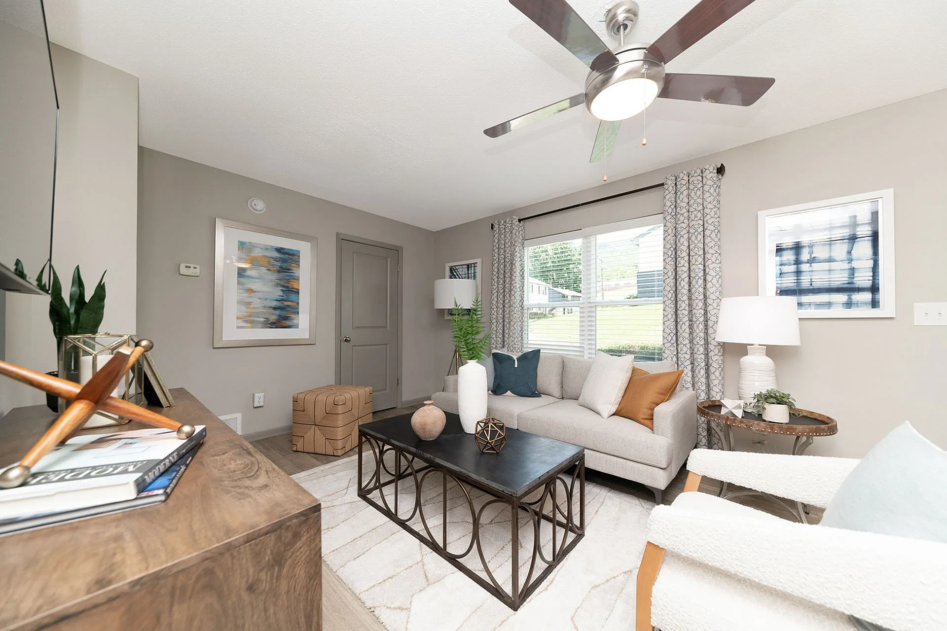 Bright and stylish living room featuring a cozy beige sofa, elegant decor, and large window with natural light.