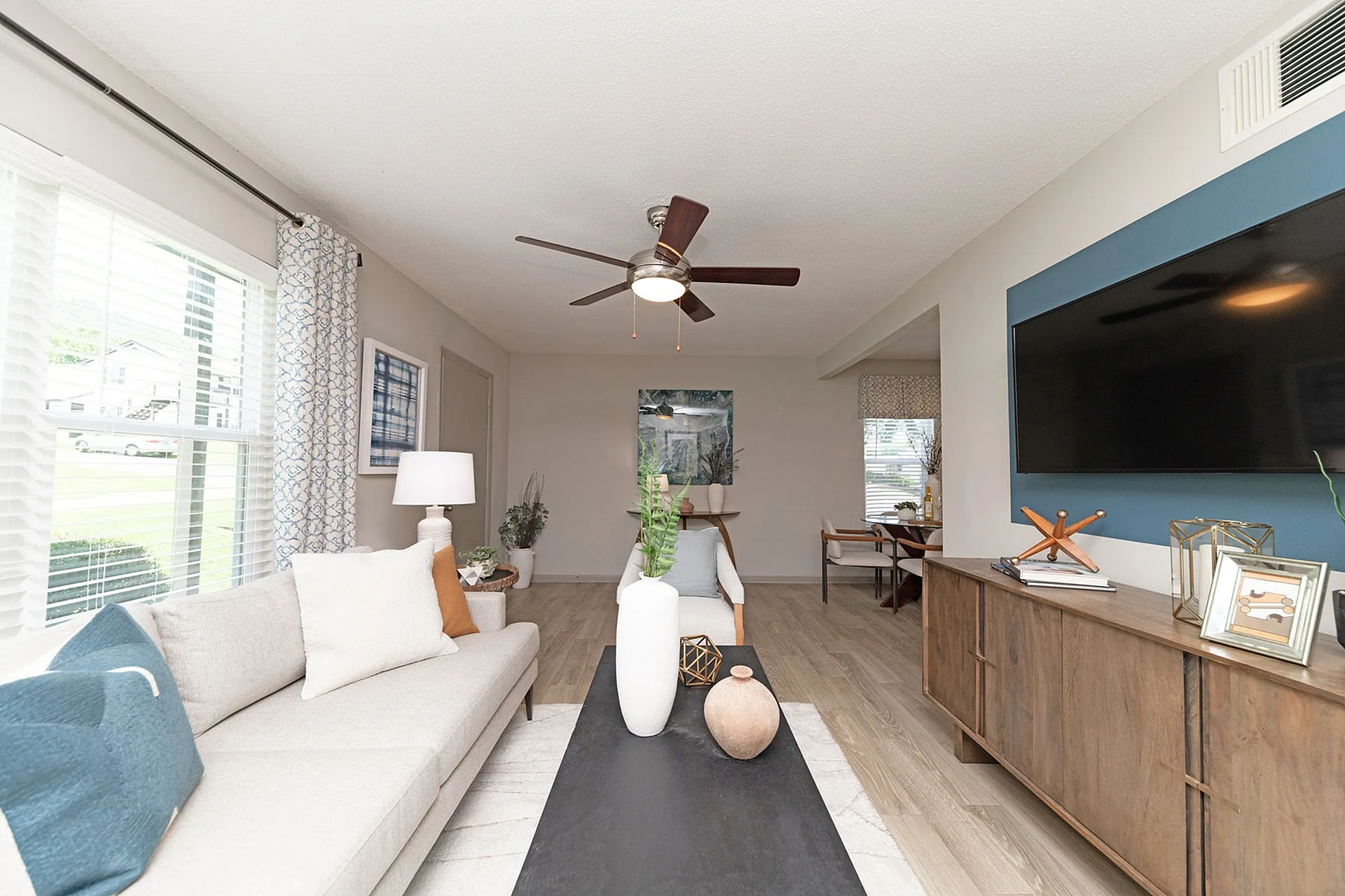 Modern living room with stylish decor, featuring a comfortable sofa, elegant coffee table, and wall-mounted TV.