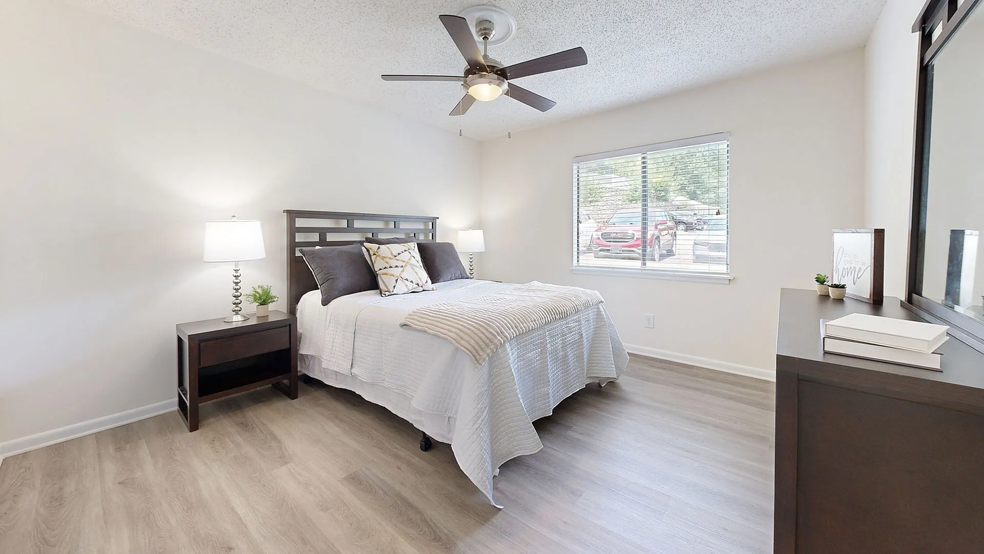 Inviting bedroom with modern decor, featuring a cozy bed, stylish nightstands, and a large window that fills the room with natural light.