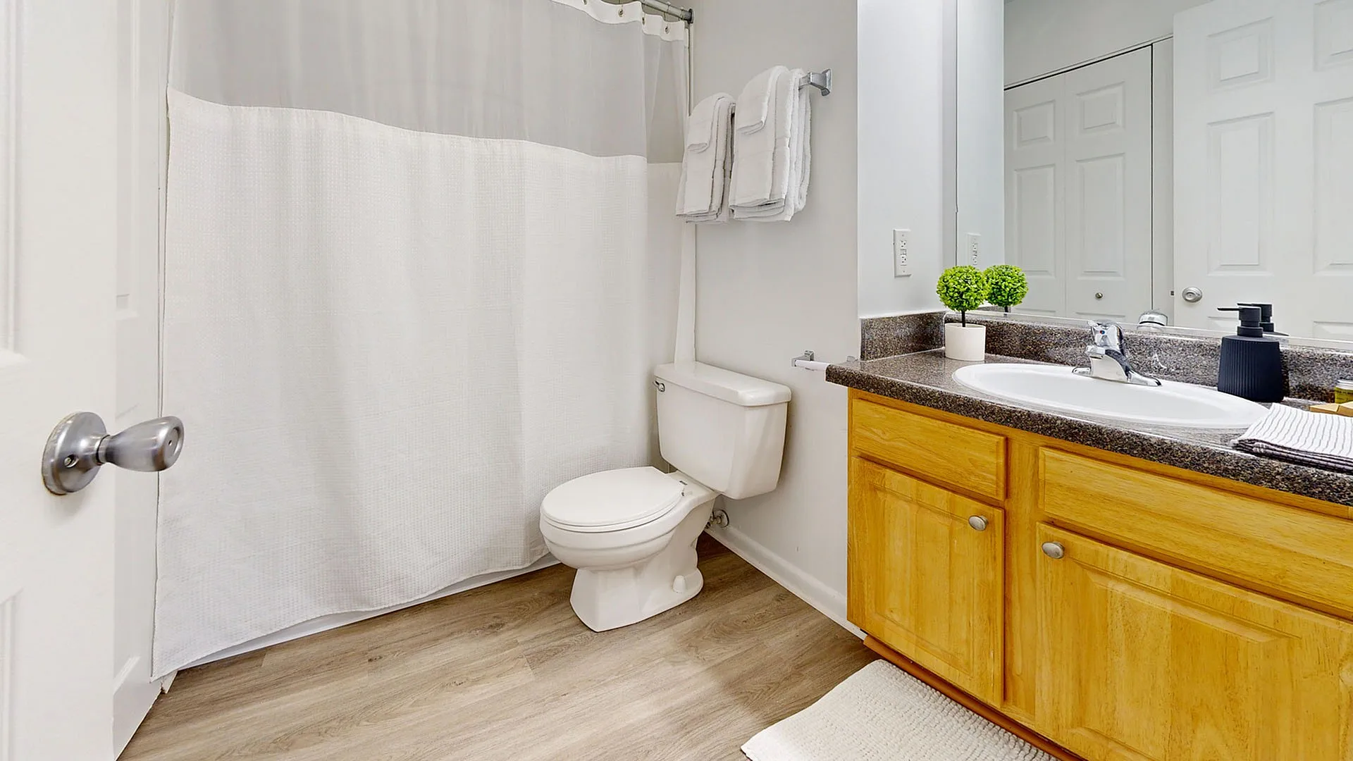 Bright and modern bathroom featuring a sleek granite countertop, elegant wooden cabinetry, and a serene atmosphere.
