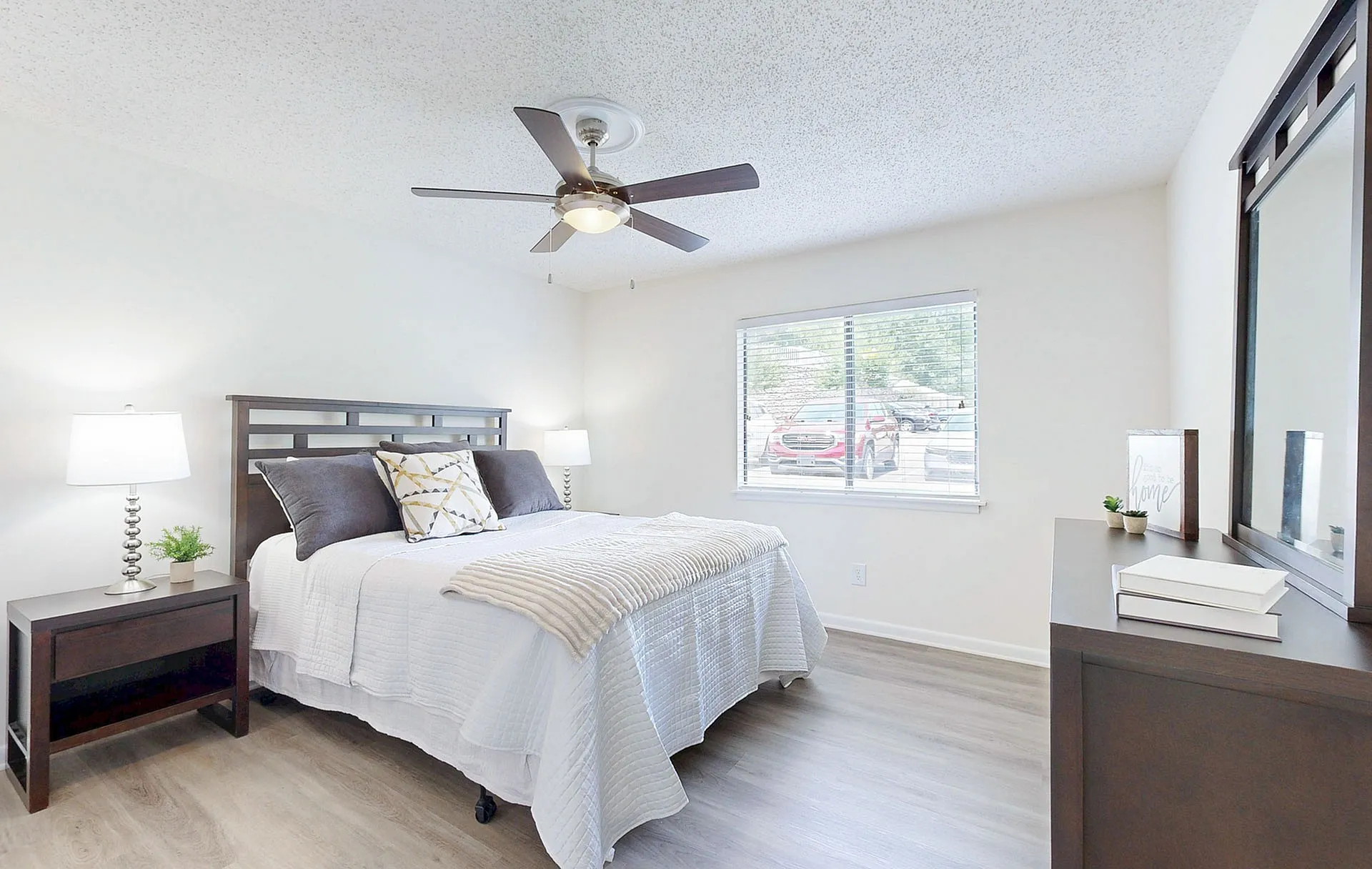 Bright and inviting bedroom with elegant decor, featuring a plush bed, stylish nightstands, and ample natural light streaming through large windows.