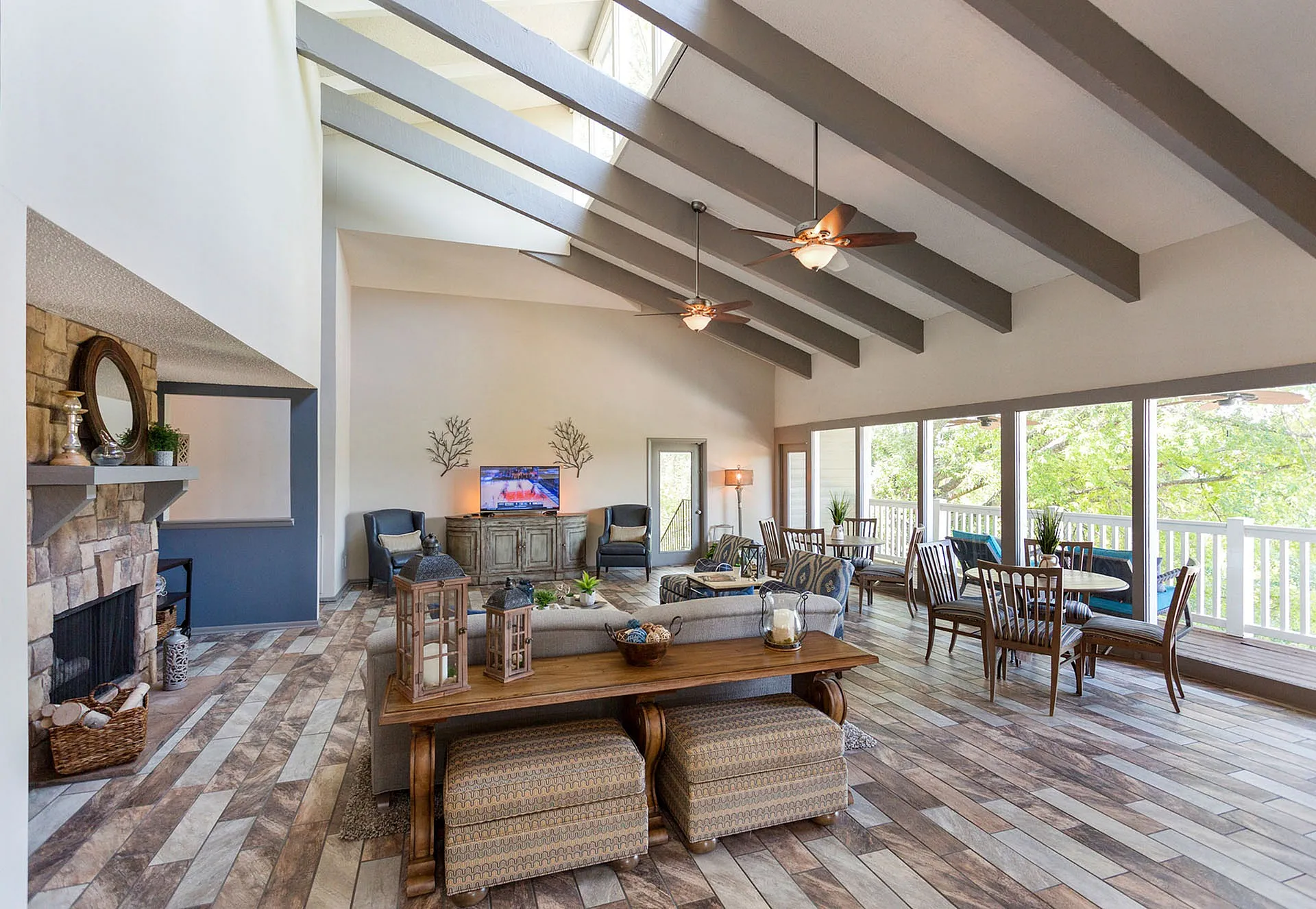 Elegant living room with vaulted ceiling, stone fireplace, and large windows offering abundant natural light.
