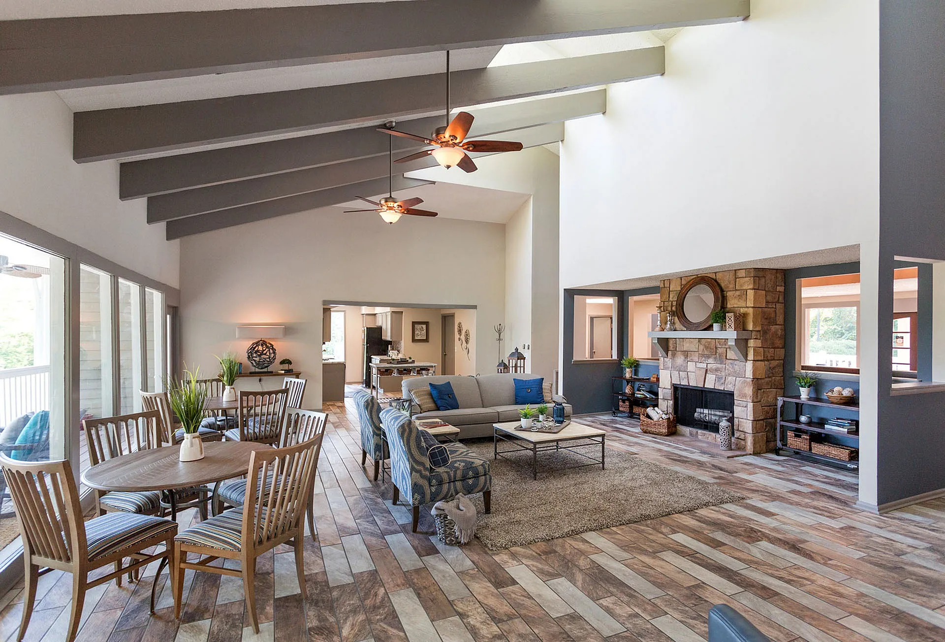 Inviting open-concept living room with vaulted ceilings, cozy fireplace, and stylish dining area, perfect for entertaining and relaxation.
