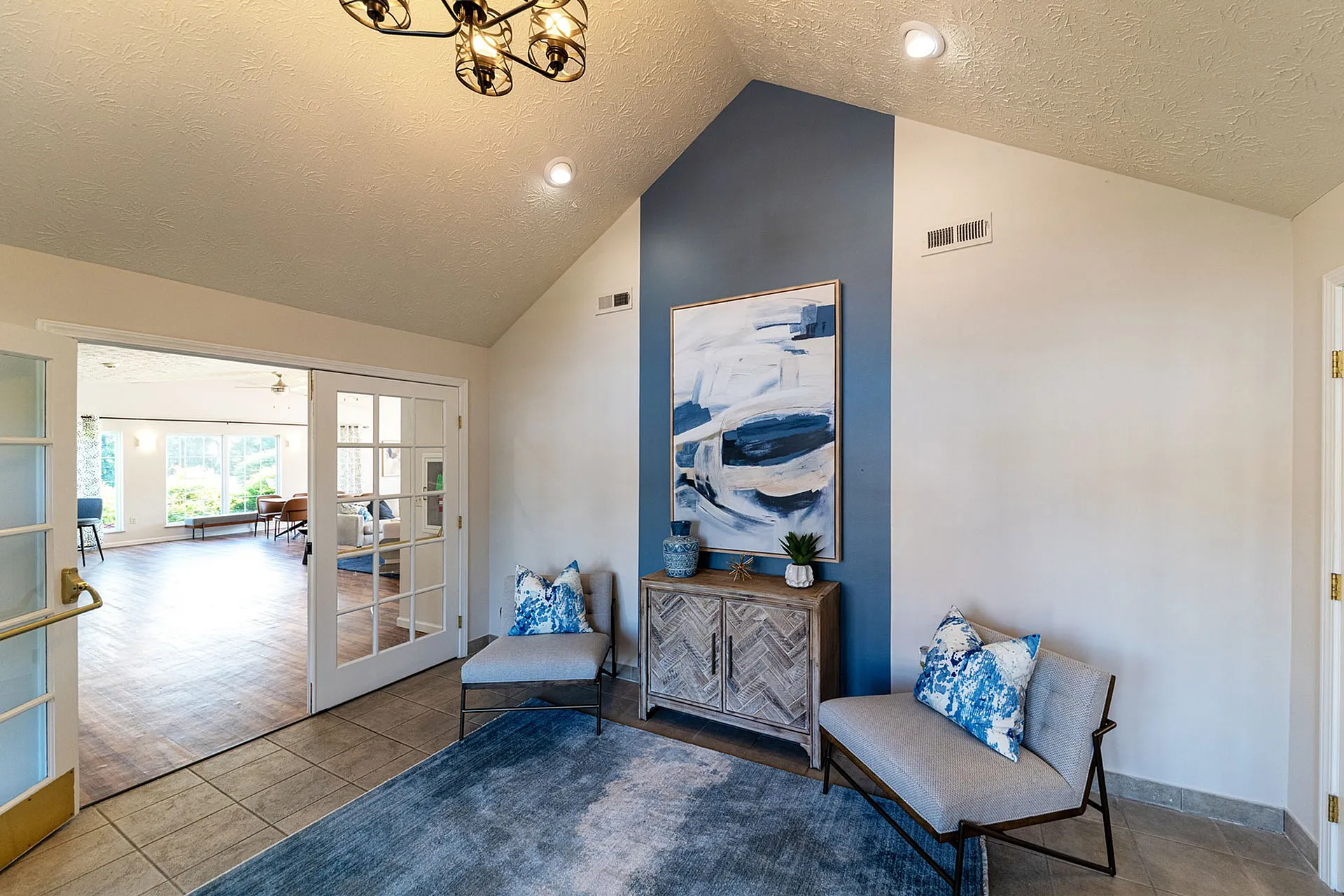 Chic apartment entryway featuring modern decor, stylish seating, and elegant lighting leading to a spacious living area.