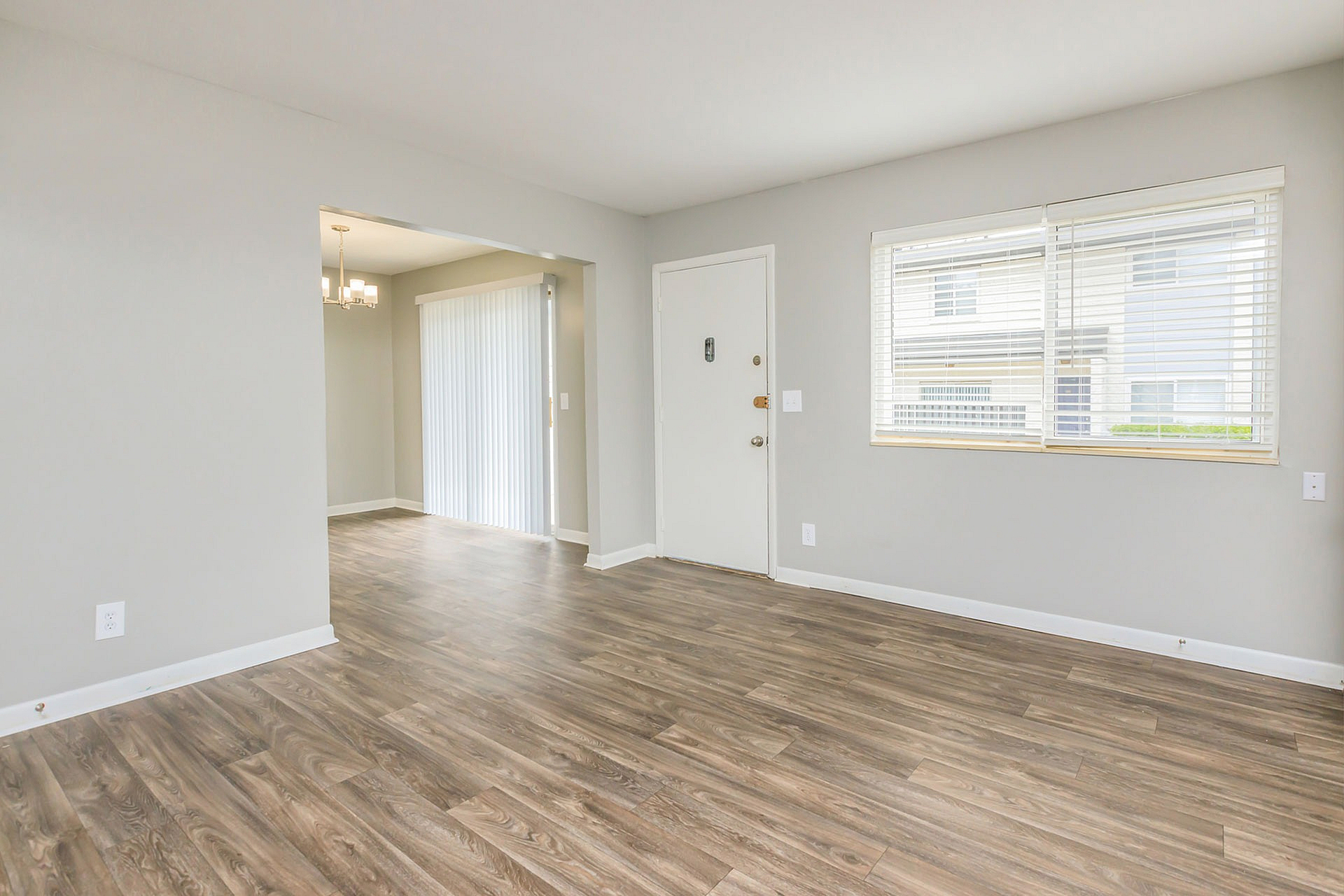 Bright and inviting living space with elegant wood flooring and large windows, offering a blend of modern style and comfort.