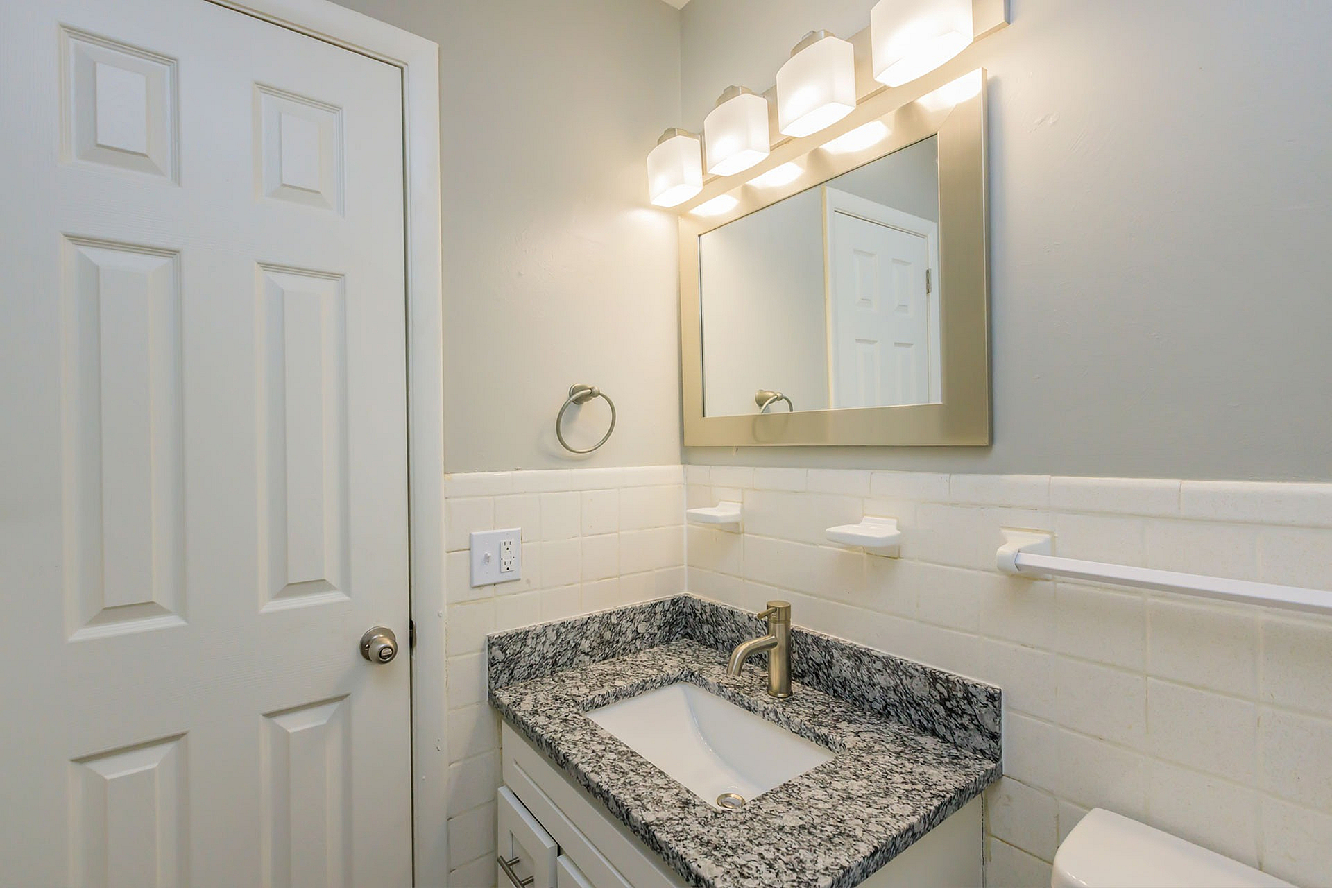 Modern bathroom with stylish granite countertop, sleek fixtures, and soft ambient lighting.